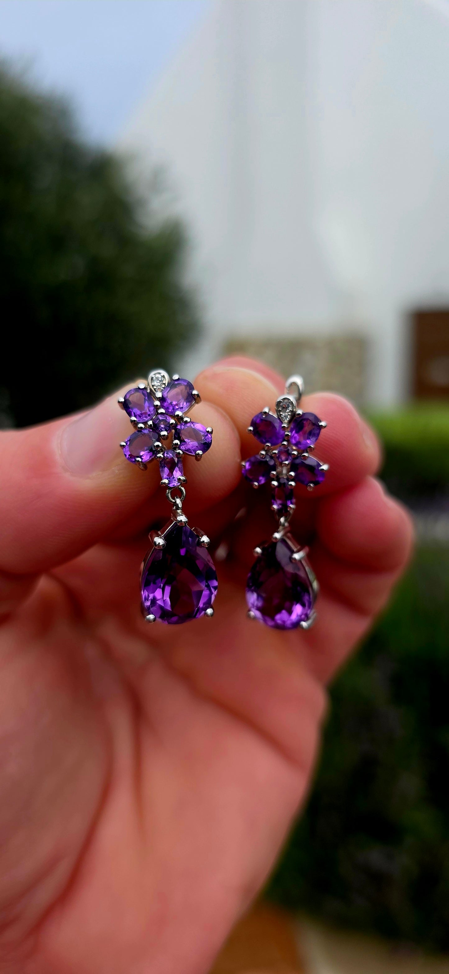 Enchanting, feminine, and absolutely drenched in purple sparkle... these beautiful sterling silver and amethyst drop earrings have the most wonderful floral design, almost resembling a pair of jewelled orchids.