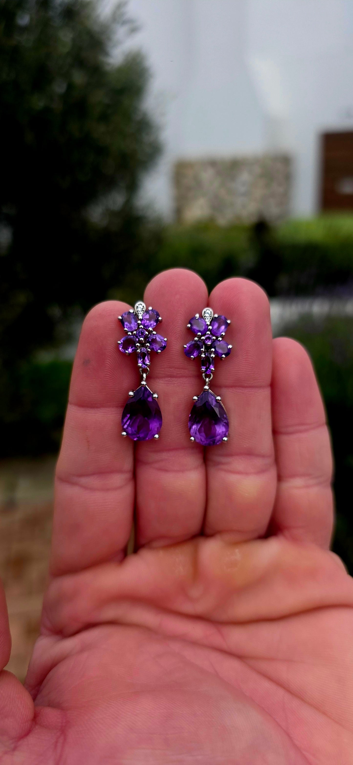 Enchanting, feminine, and absolutely drenched in purple sparkle... these beautiful sterling silver and amethyst drop earrings have the most wonderful floral design, almost resembling a pair of jewelled orchids.