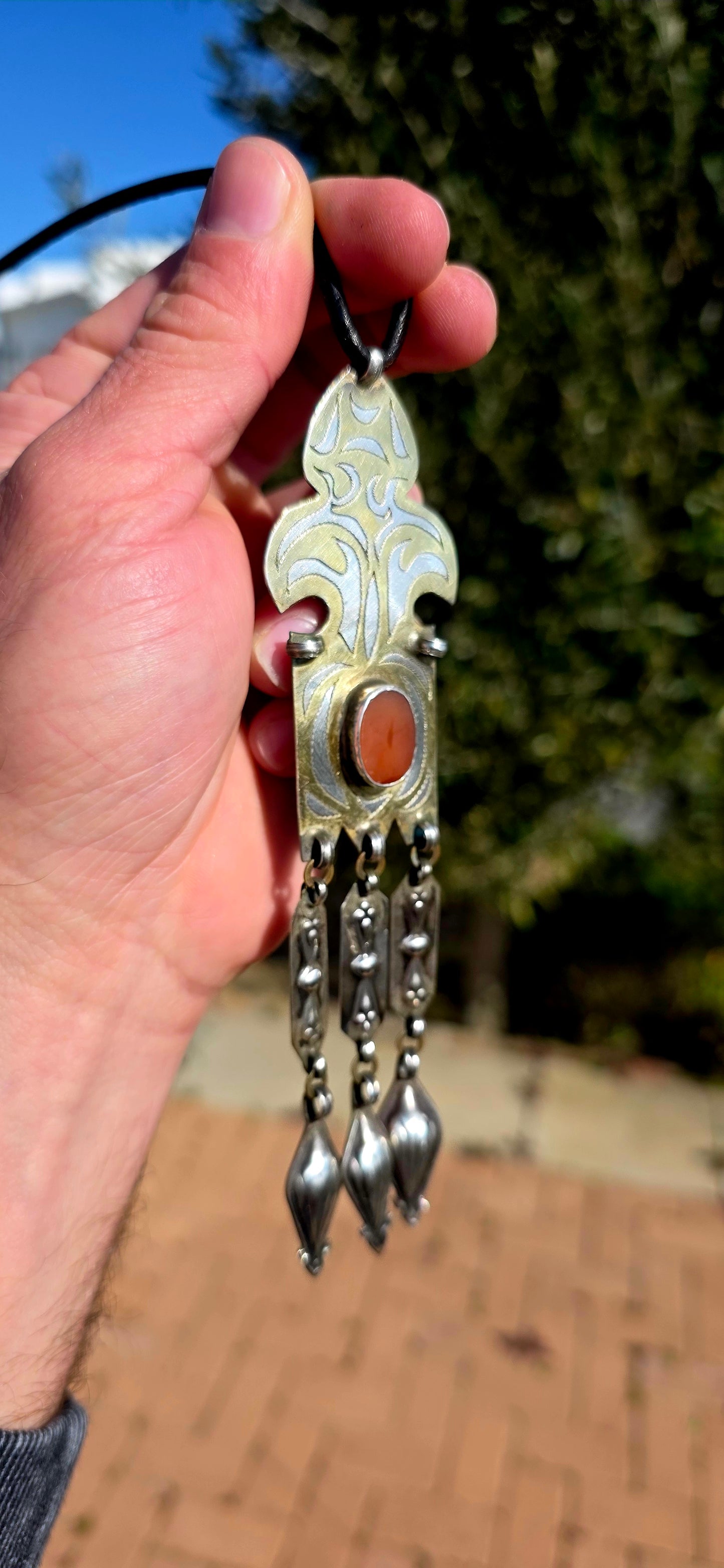 This antique Turkoman pendant is beautifully crafted in sterling silver, with contrasting gold-plated accents highlighting the bold engraved decoration.