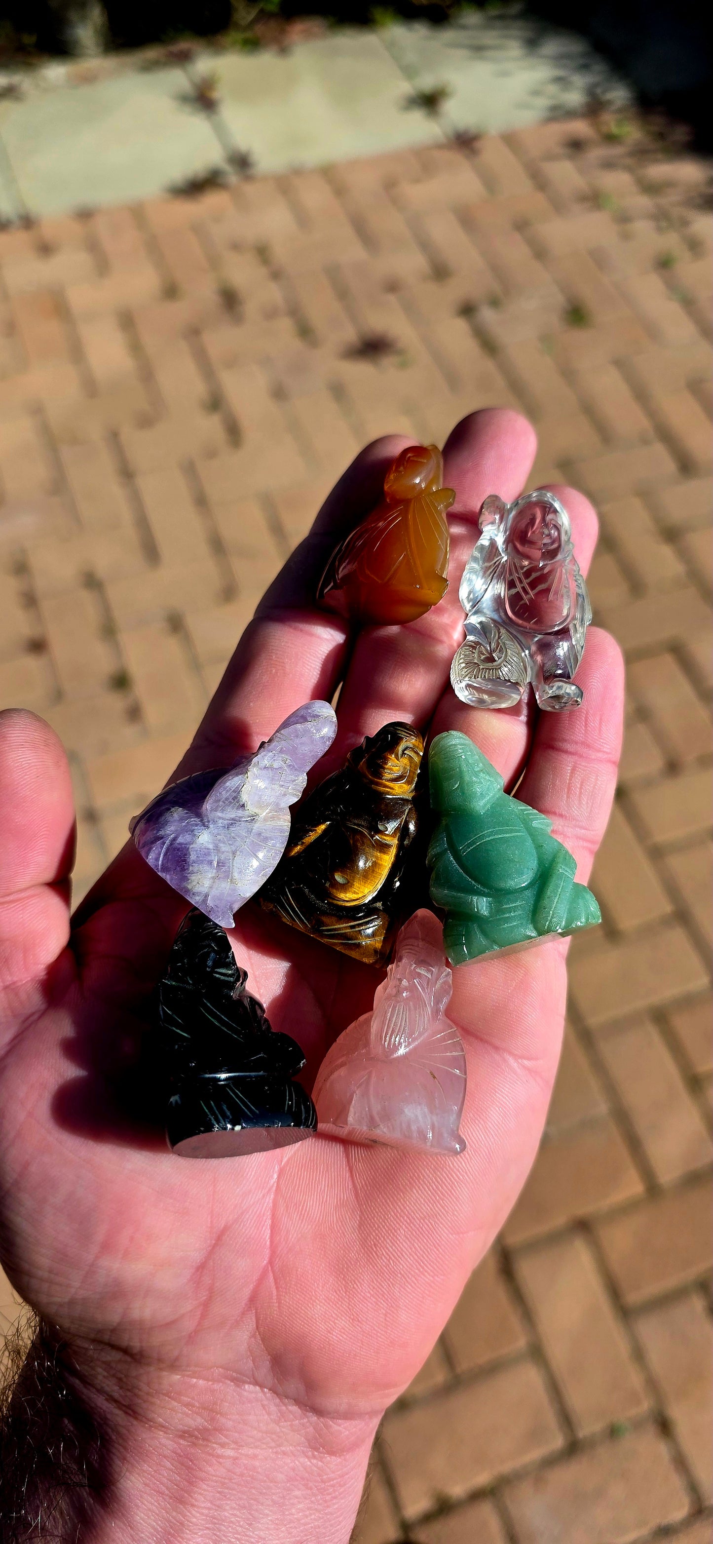 A wonderfully colourful vintage collection of seven miniature Chinese-deity and auspicious figure carvings, each individually hand-carved from a different natural gemstone.