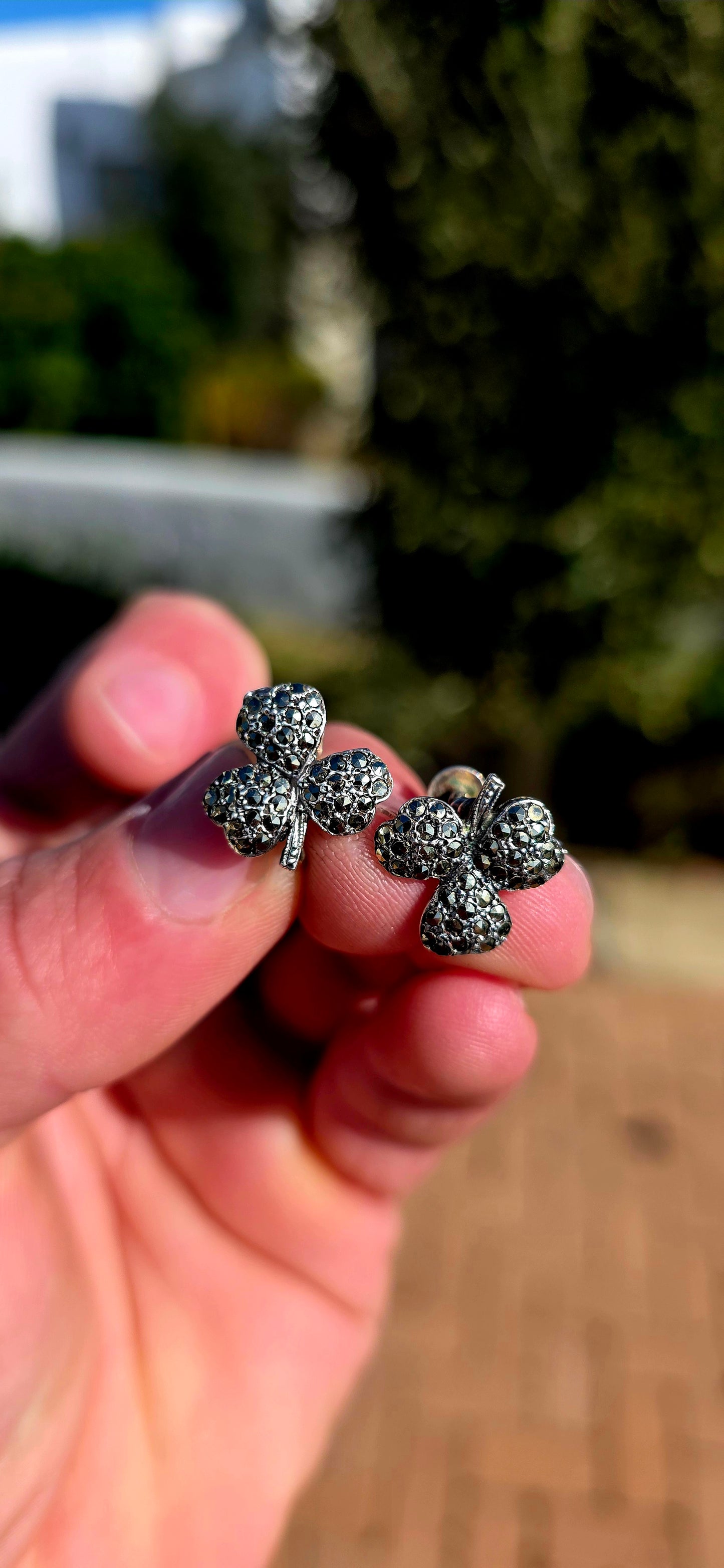 A wonderfully charming pair of Art Deco-era sterling silver screw-back earrings, each fashioned as a beautifully dimensional three-leaf clover and glittering with tiny marcasites.