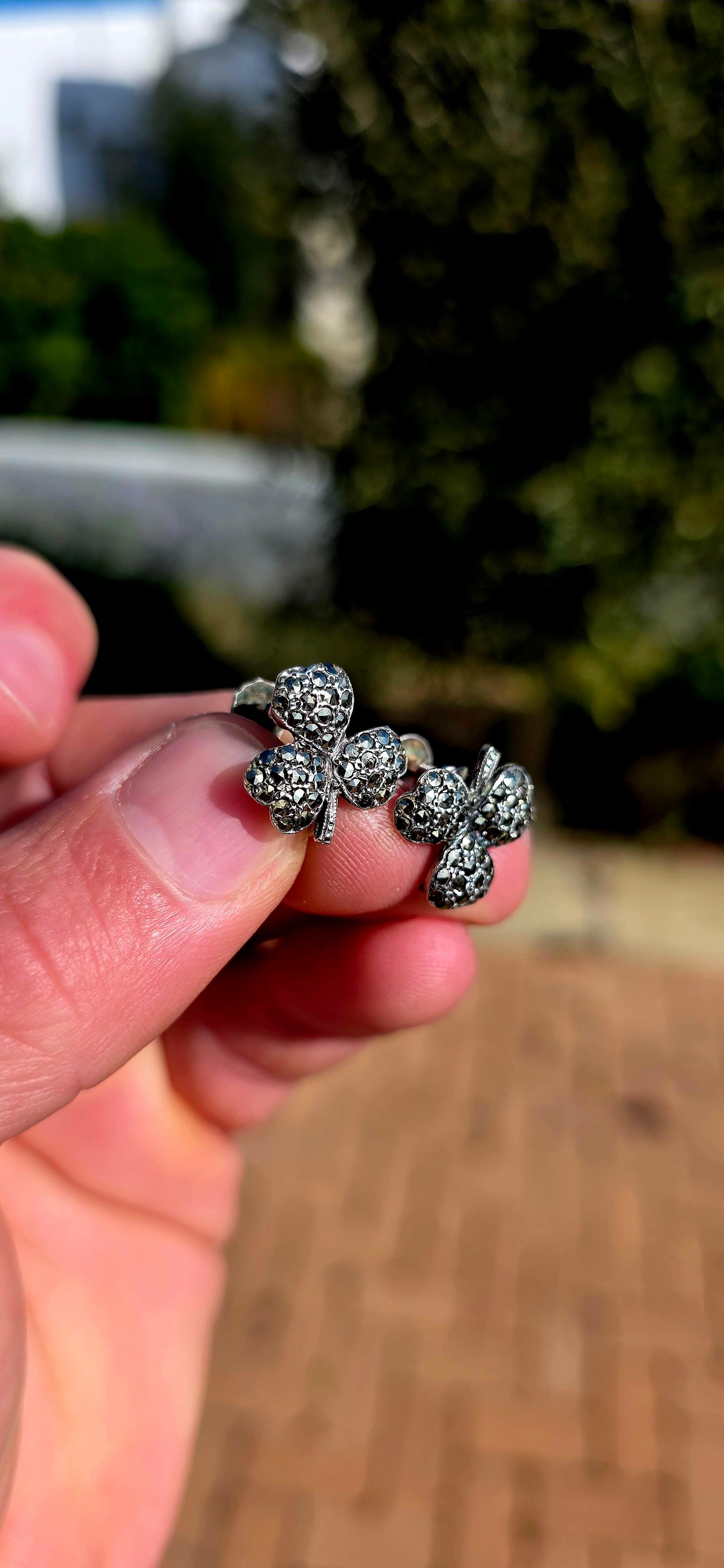 A wonderfully charming pair of Art Deco-era sterling silver screw-back earrings, each fashioned as a beautifully dimensional three-leaf clover and glittering with tiny marcasites.