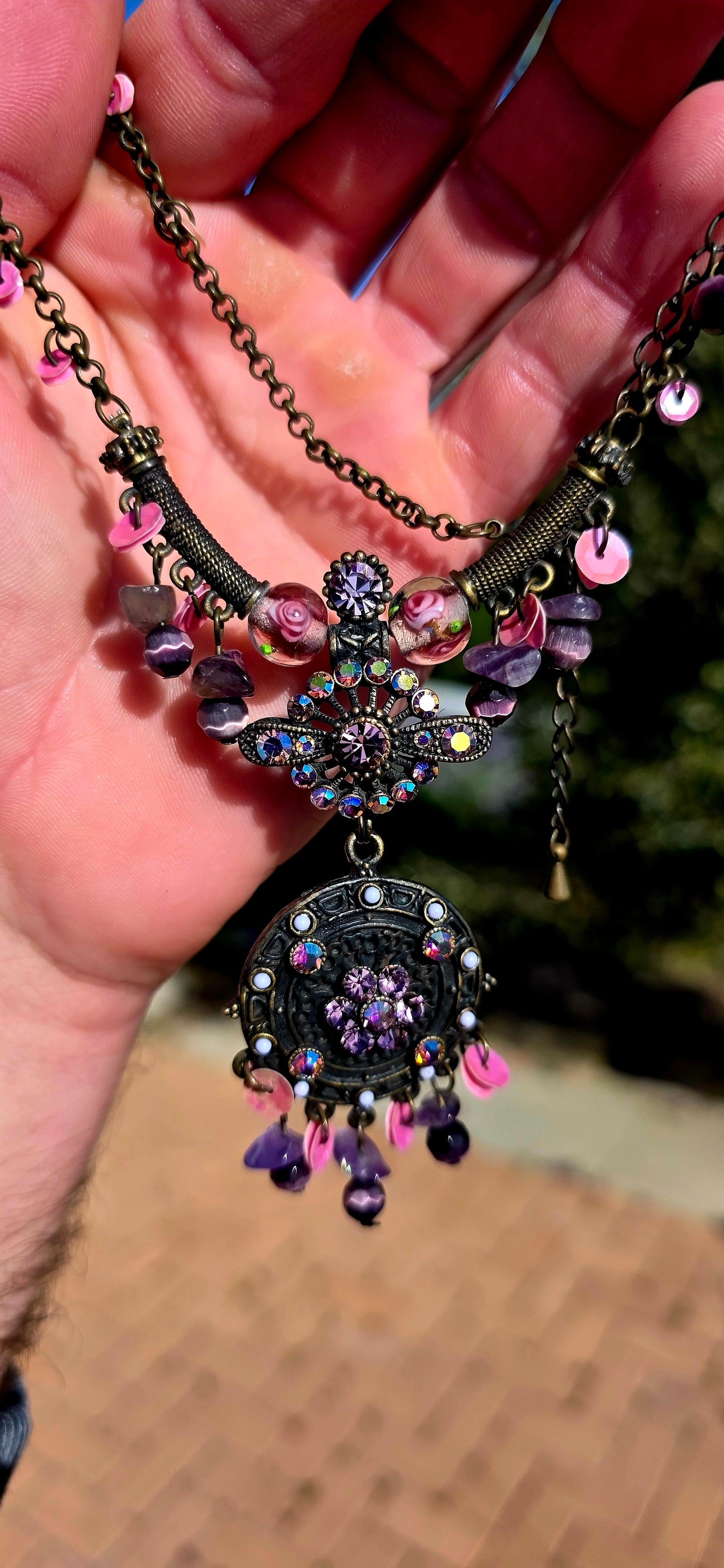 A beautifully handmade statement costume necklace, crafted in antique-bronze-tone metal and dripping with gorgeous shades of amethyst, violet, lavender and pink.