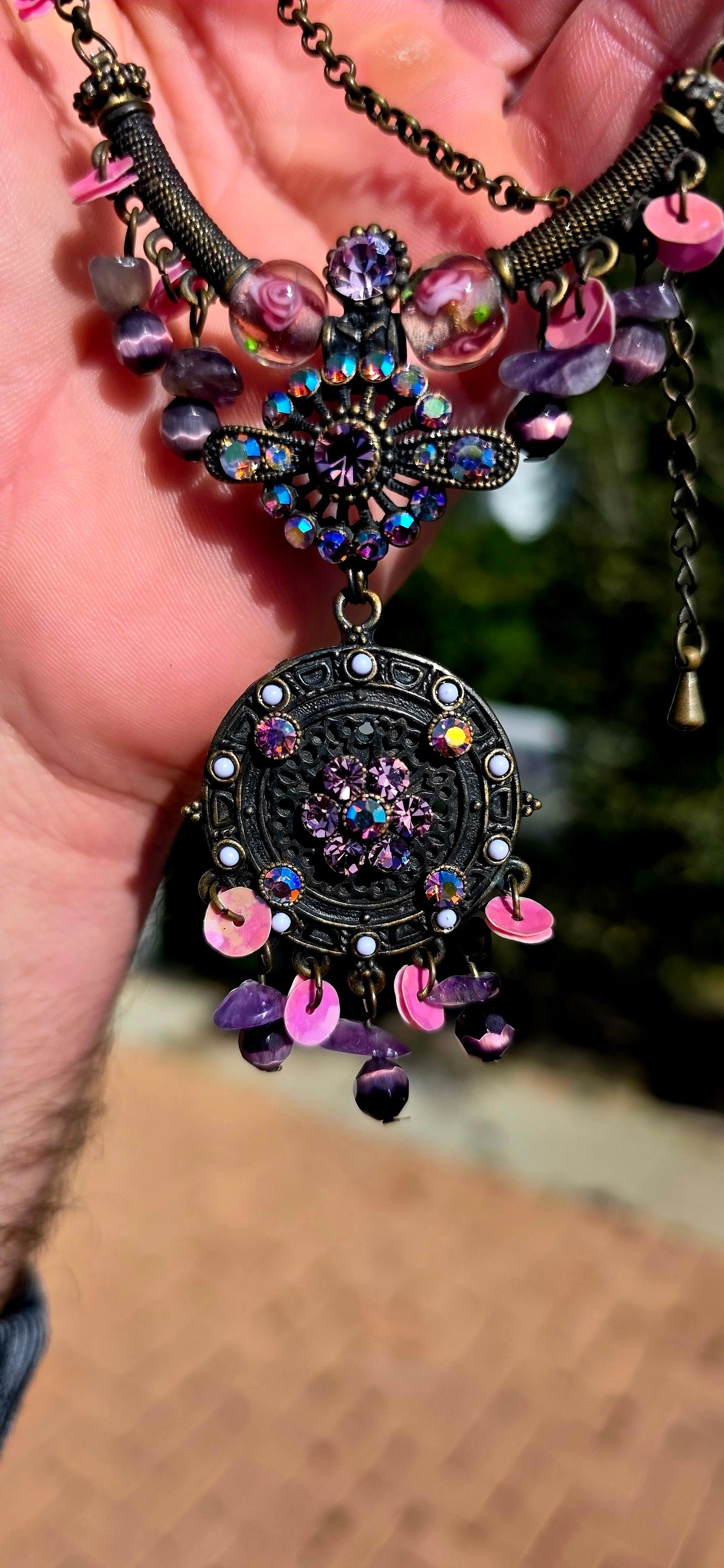 A beautifully handmade statement costume necklace, crafted in antique-bronze-tone metal and dripping with gorgeous shades of amethyst, violet, lavender and pink.
