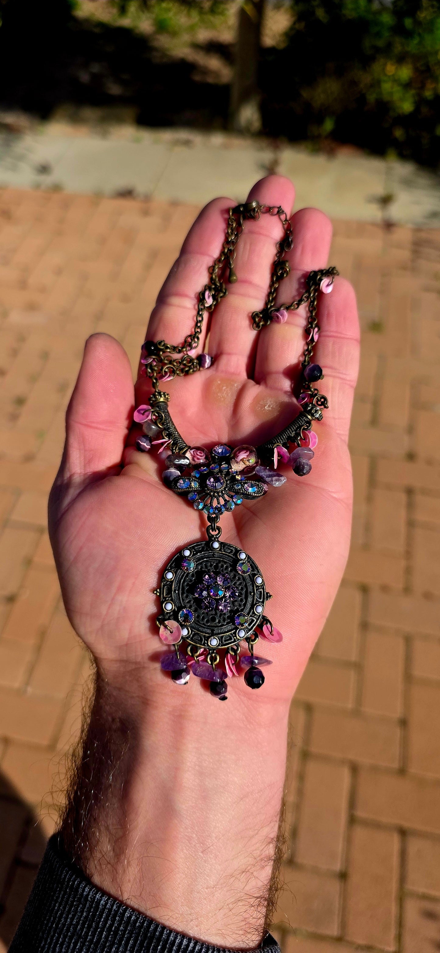 A beautifully handmade statement costume necklace, crafted in antique-bronze-tone metal and dripping with gorgeous shades of amethyst, violet, lavender and pink.
