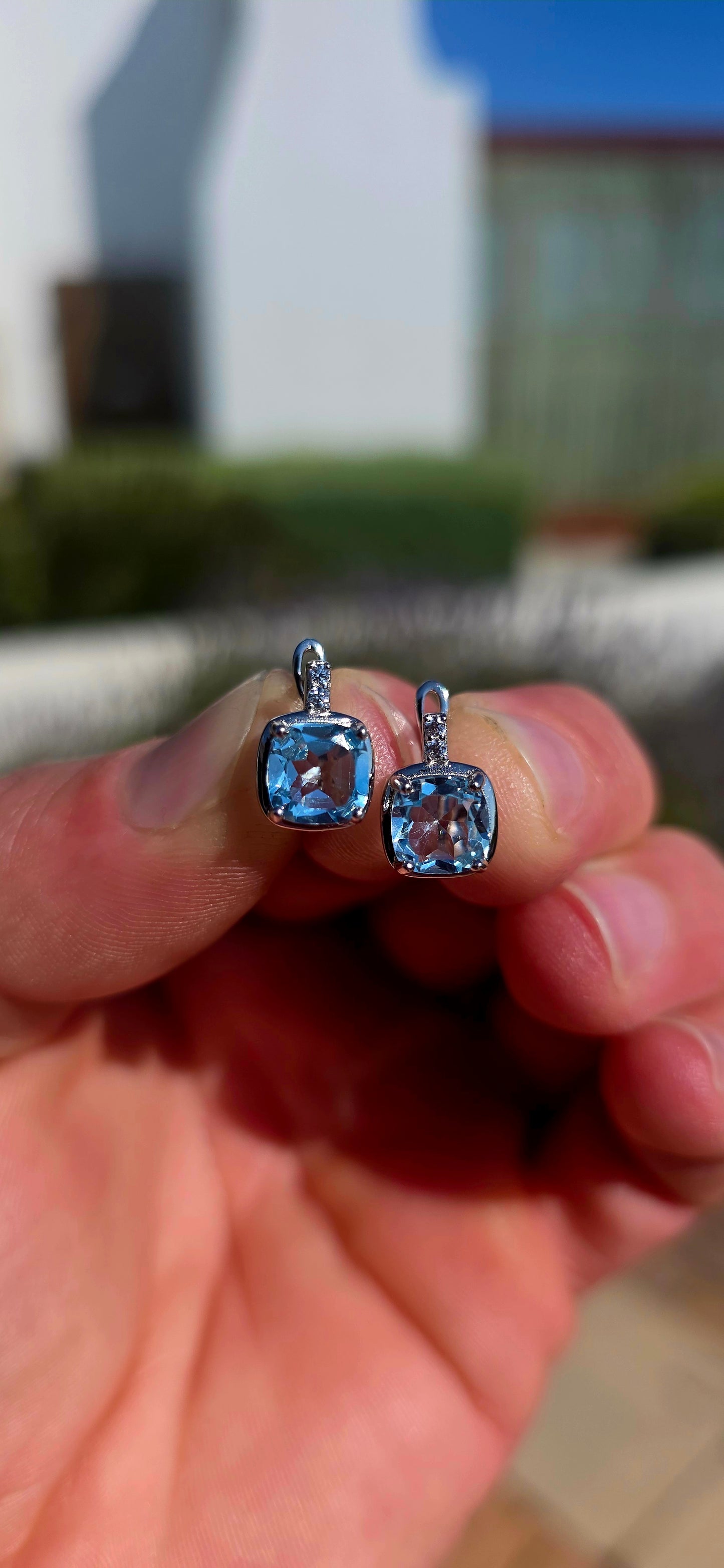 Fresh, elegant and SO beautifully sparkly! These gorgeous sterling silver drop earrings each feature a generously sized cushion-cut sky blue topaz, glowing in the prettiest crystal-clear icy blue.