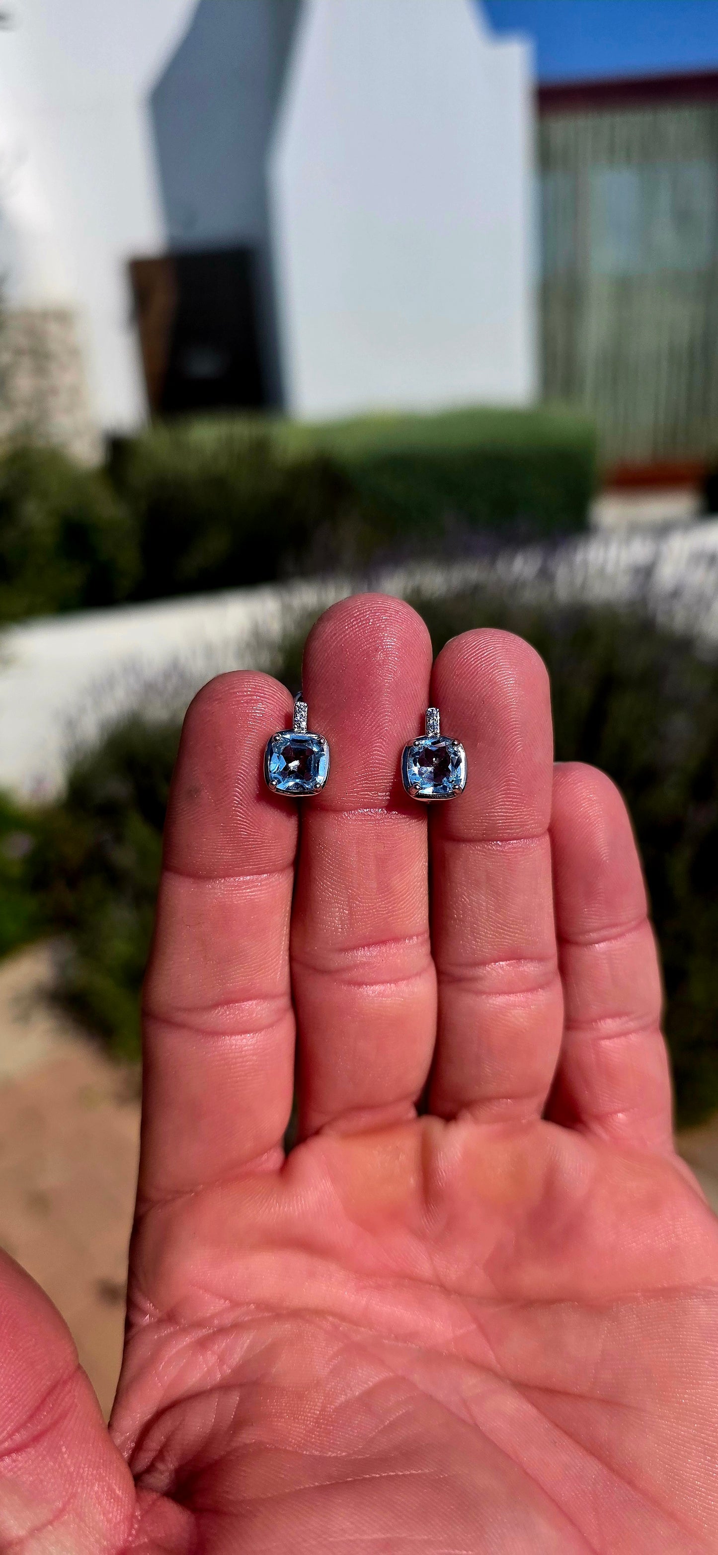Fresh, elegant and SO beautifully sparkly! These gorgeous sterling silver drop earrings each feature a generously sized cushion-cut sky blue topaz, glowing in the prettiest crystal-clear icy blue.