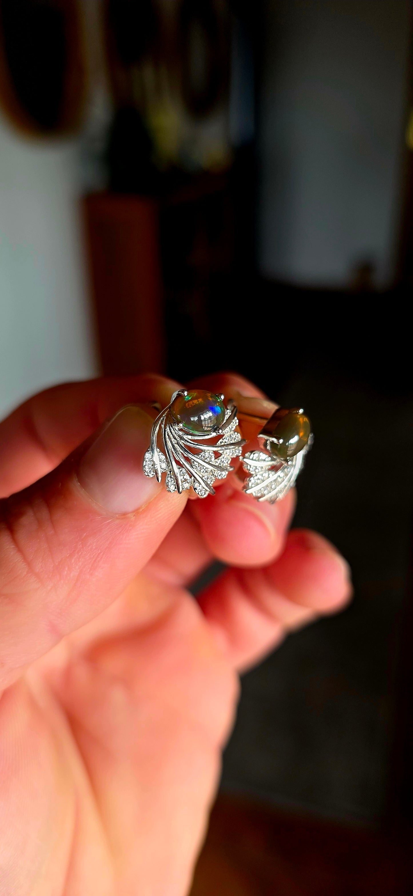 These enchanting sterling silver earrings each feature an oval dark-bodied Ethiopian opal cabochon, displaying those magical flashes of green, orange, gold and blue as they move through the light.