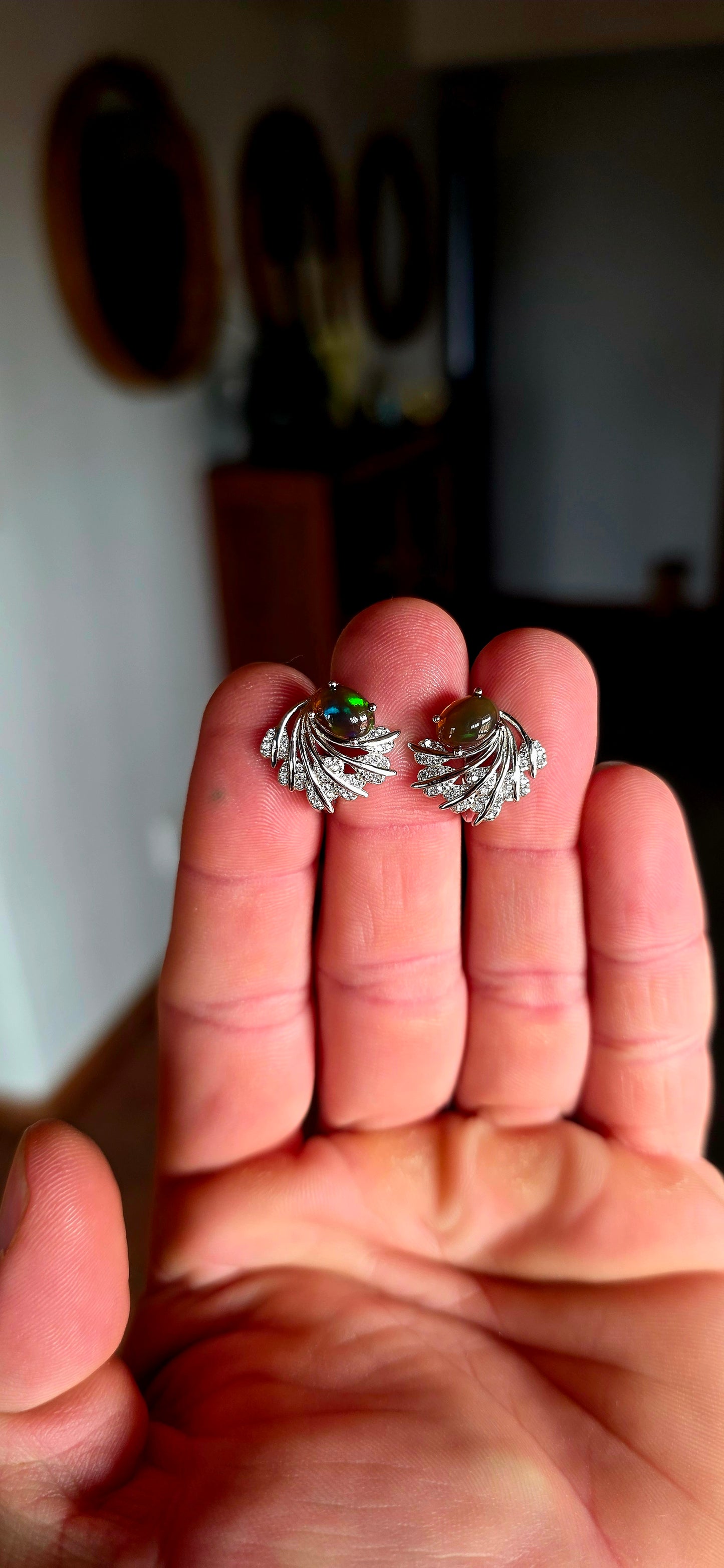 These enchanting sterling silver earrings each feature an oval dark-bodied Ethiopian opal cabochon, displaying those magical flashes of green, orange, gold and blue as they move through the light.