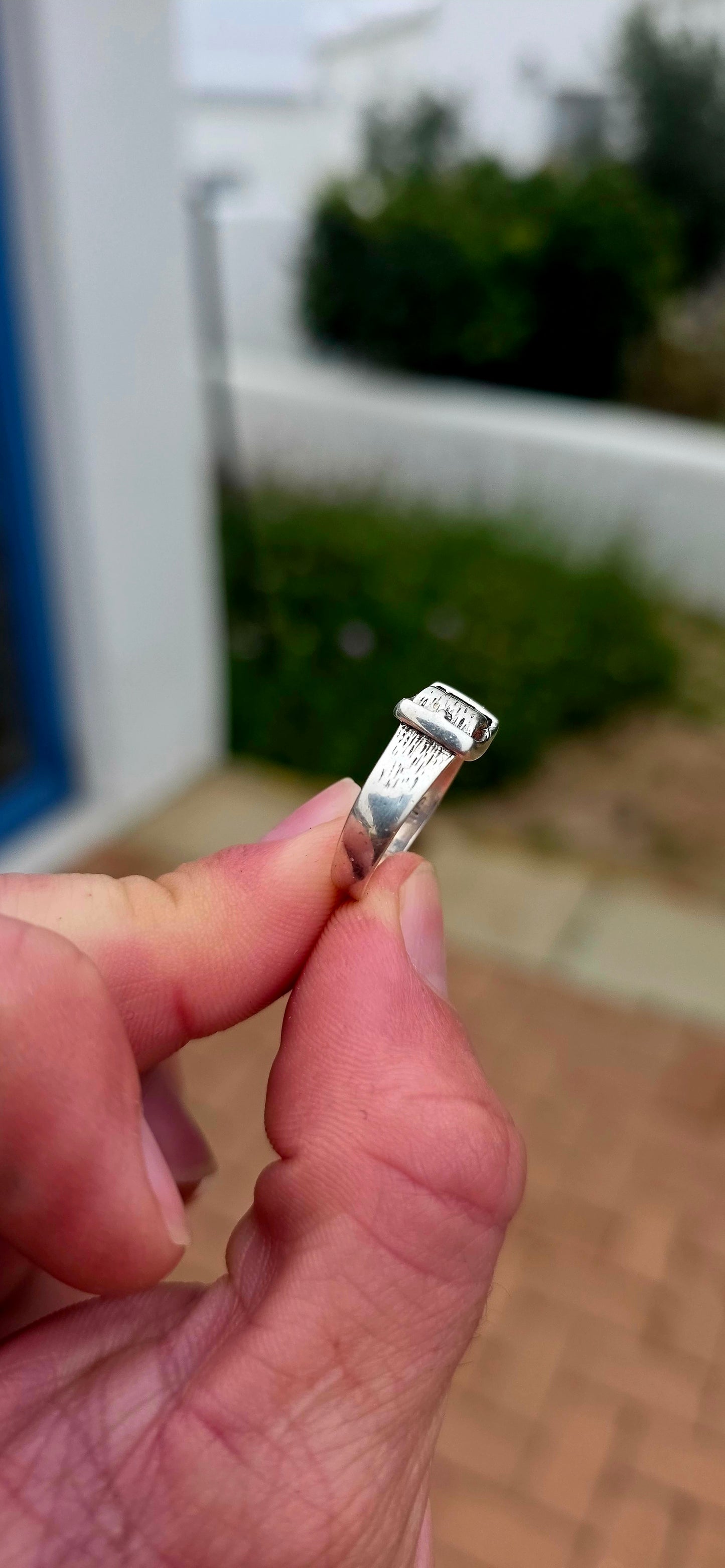 A vintage sterling silver Victorian Revival pinky ring, fashioned in the form of a miniature belt and buckle, complete with wonderful textured detailing and a raised buckle across the front.