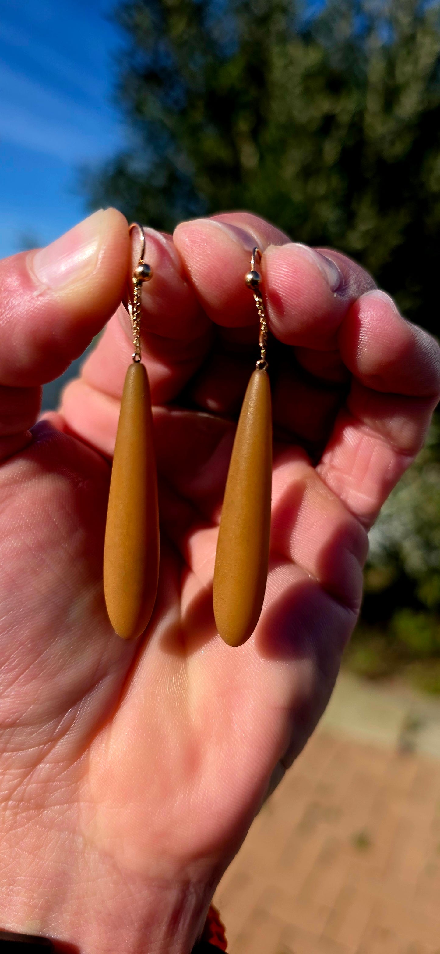 An absolutely fabulous and wonderfully unusual pair of antique Edwardian-era drop earrings, combining warm 9ct rose gold with beautifully elongated caramel-brown Bakelite torpedo drops.
