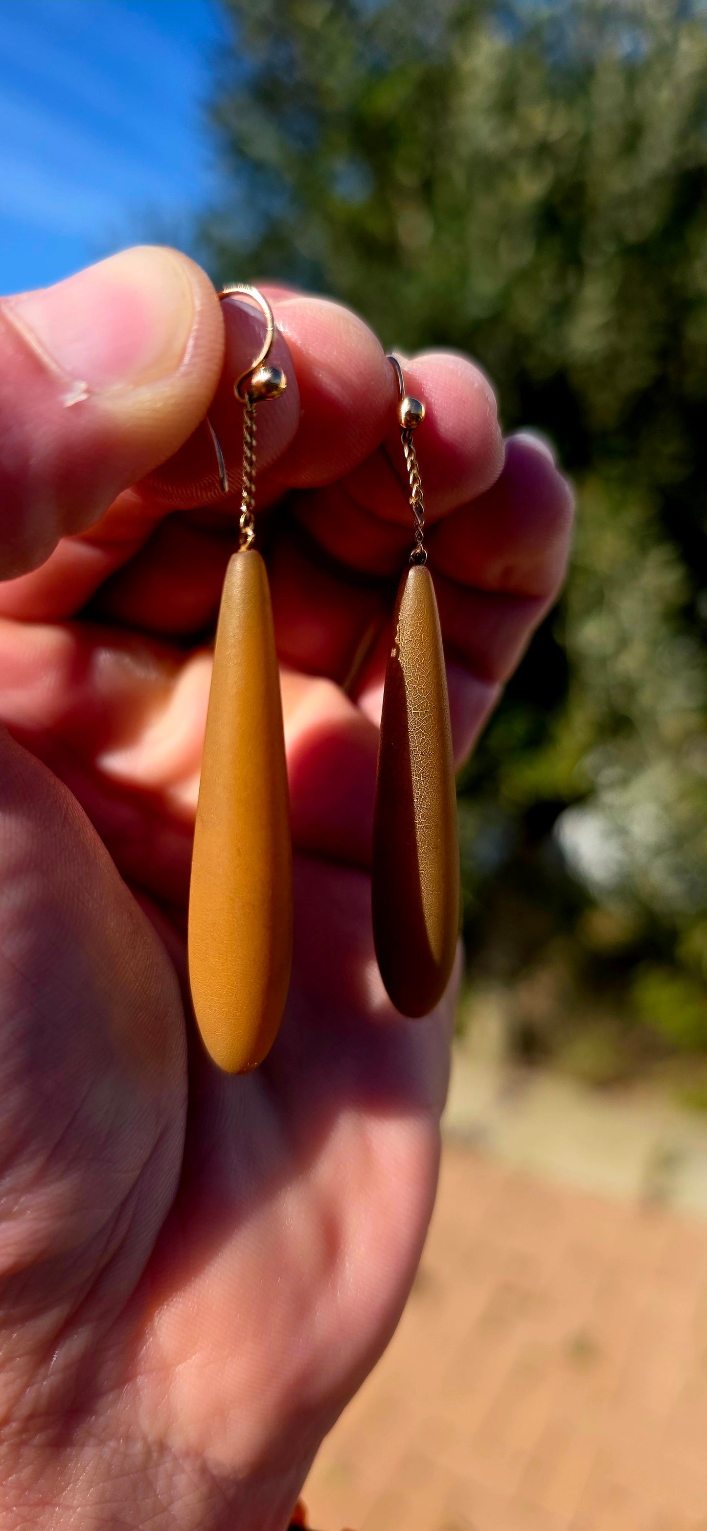 An absolutely fabulous and wonderfully unusual pair of antique Edwardian-era drop earrings, combining warm 9ct rose gold with beautifully elongated caramel-brown Bakelite torpedo drops.