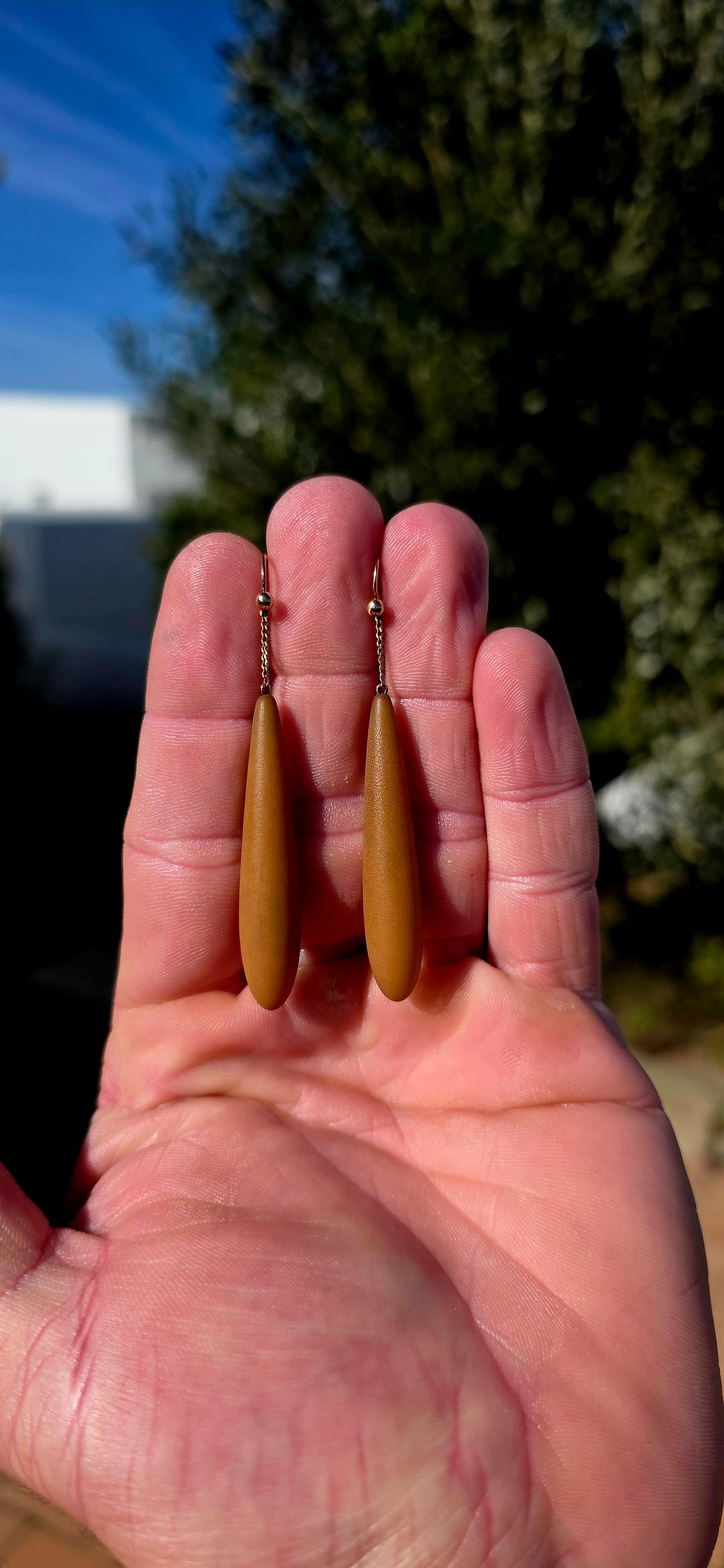 An absolutely fabulous and wonderfully unusual pair of antique Edwardian-era drop earrings, combining warm 9ct rose gold with beautifully elongated caramel-brown Bakelite torpedo drops.