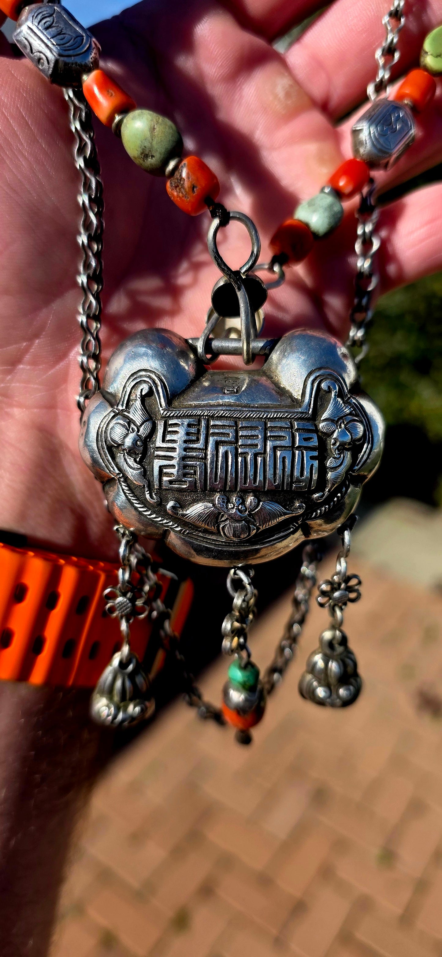An absolutely extraordinary antique Chinese Qing Dynasty / early 20th-century sterling silver “Longevity Lock” necklace, richly decorated with traditional auspicious imagery and strung with vibrant coral and turquoise gemstone beads.