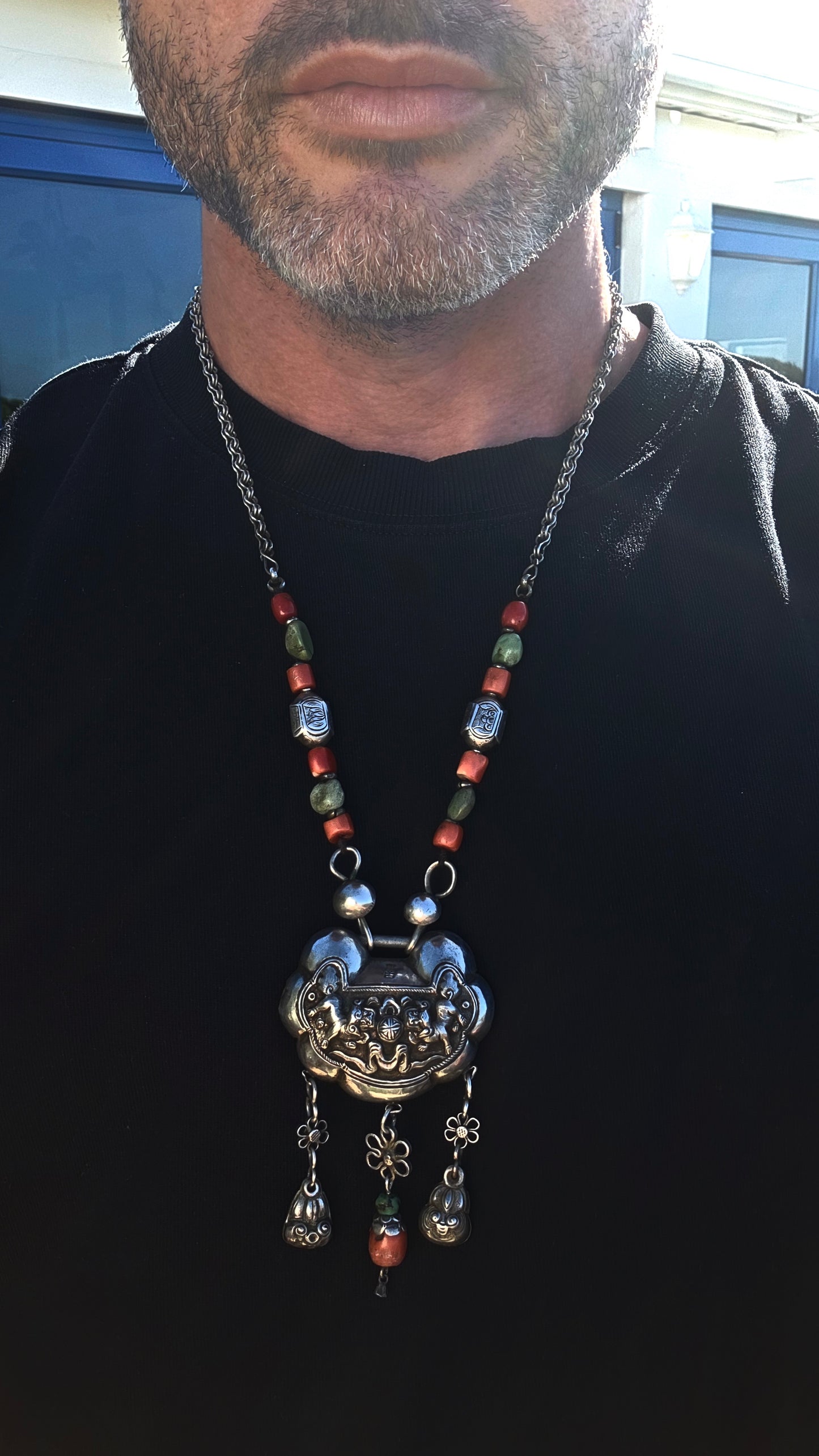 An absolutely extraordinary antique Chinese Qing Dynasty / early 20th-century sterling silver “Longevity Lock” necklace, richly decorated with traditional auspicious imagery and strung with vibrant coral and turquoise gemstone beads.