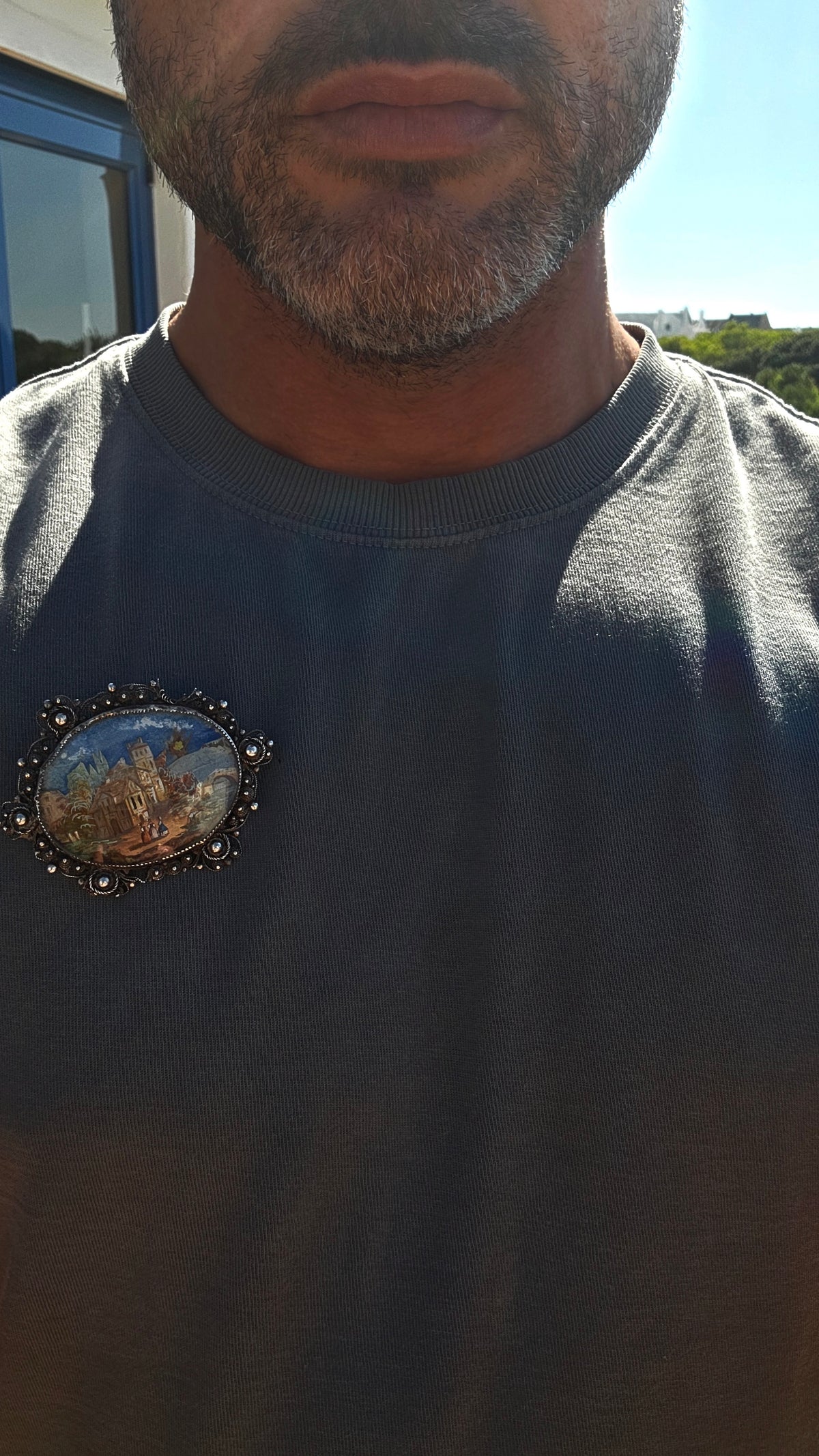 A truly beautiful and oversized antique Victorian-era sterling silver brooch, centred with a wonderfully detailed hand-painted miniature landscape scene, preserved beneath its original domed glass.