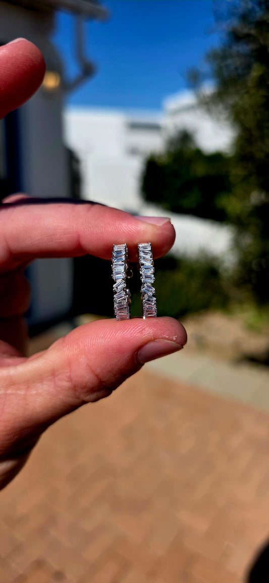 Feminine, glamorous and absolutely loaded with sparkle! These fabulous sterling silver hoop earrings are adorned all the way around with individually prong-set baguette-cut CZ gemstones.