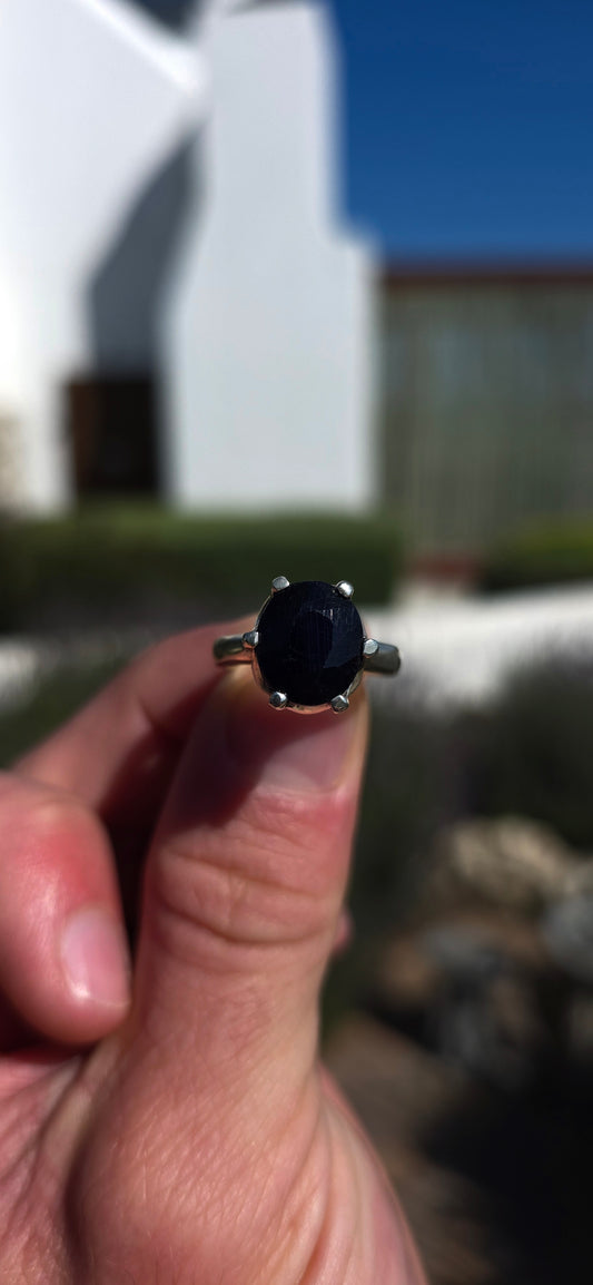 Most gorgeous sterling silver solitaire ring featuring a generously sized oval-cut sapphire in the most beautiful deep midnight-blue hue.