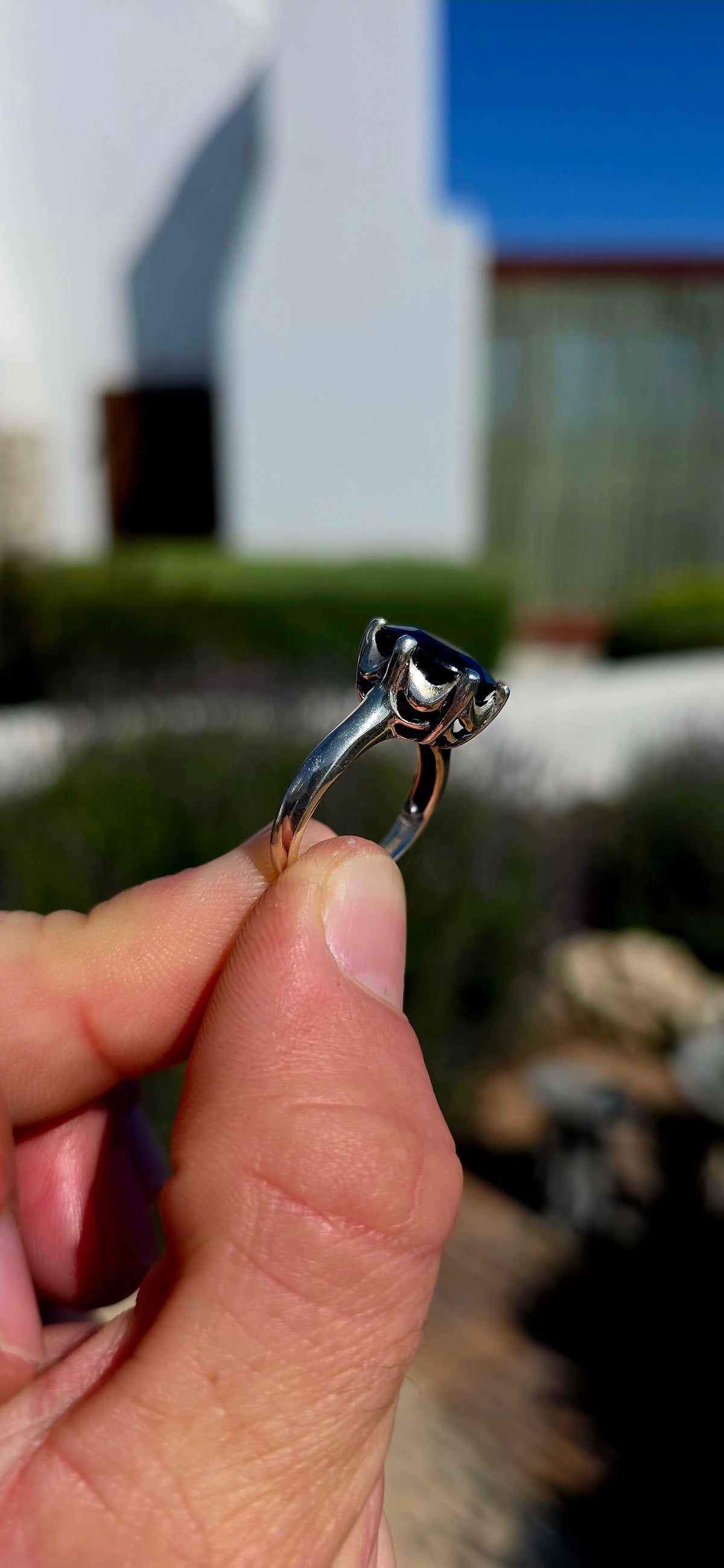Most gorgeous sterling silver solitaire ring featuring a generously sized oval-cut sapphire in the most beautiful deep midnight-blue hue.