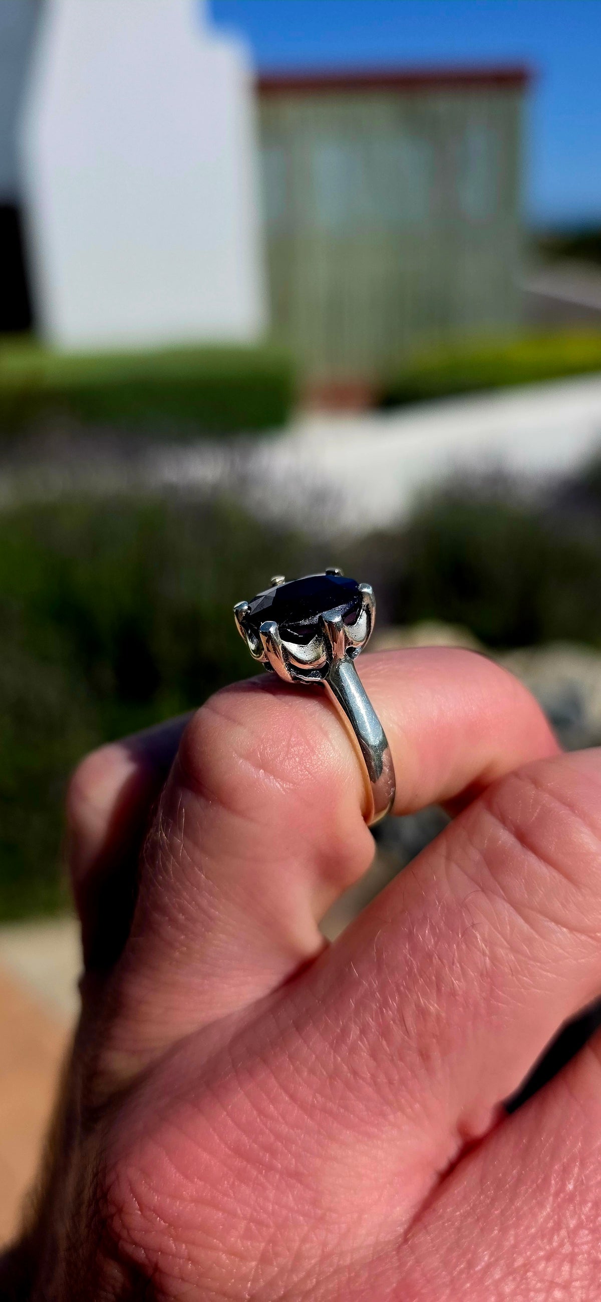 Most gorgeous sterling silver solitaire ring featuring a generously sized oval-cut sapphire in the most beautiful deep midnight-blue hue.