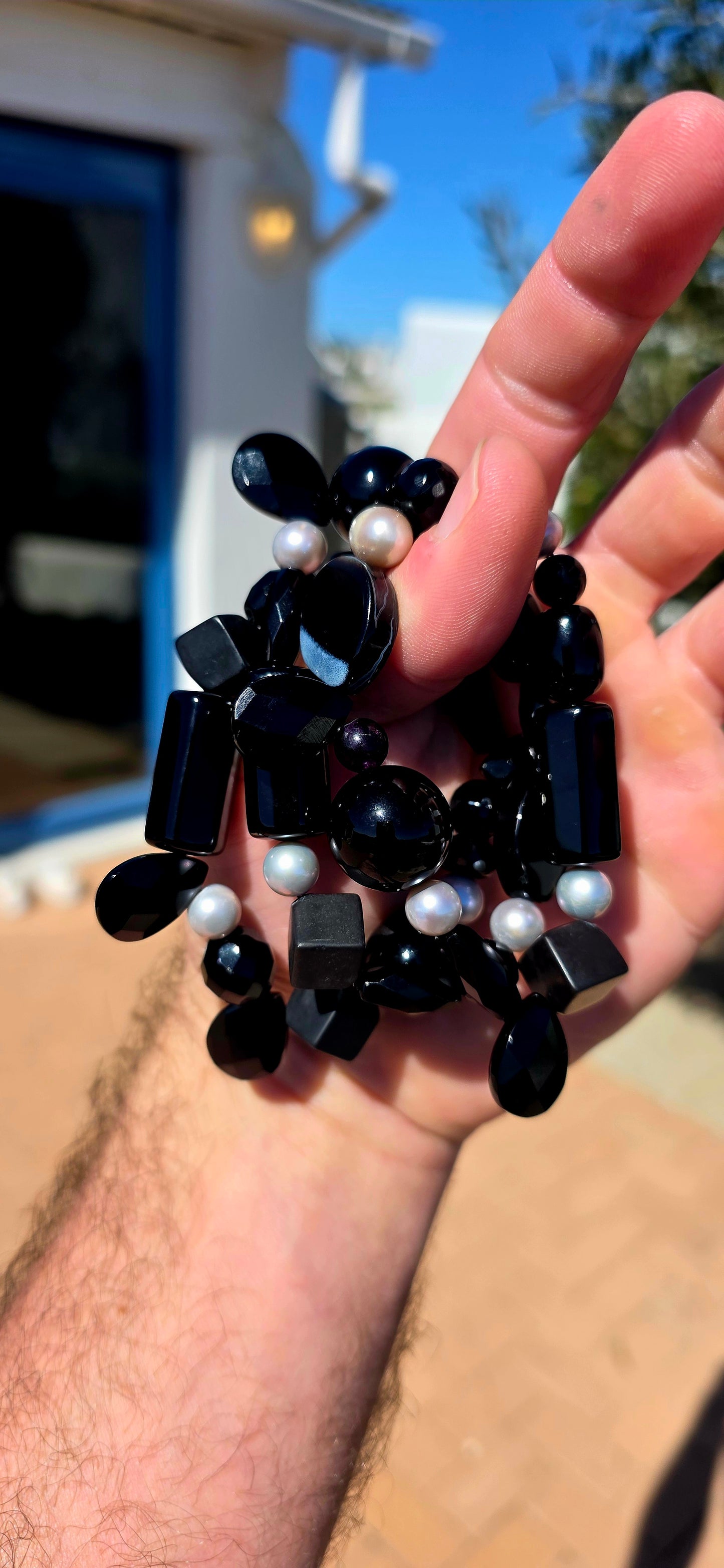 A fabulous collection of chunky gemstone stretch bracelets in dramatic shades of glossy black, beautifully contrasted with luminous freshwater pearls.