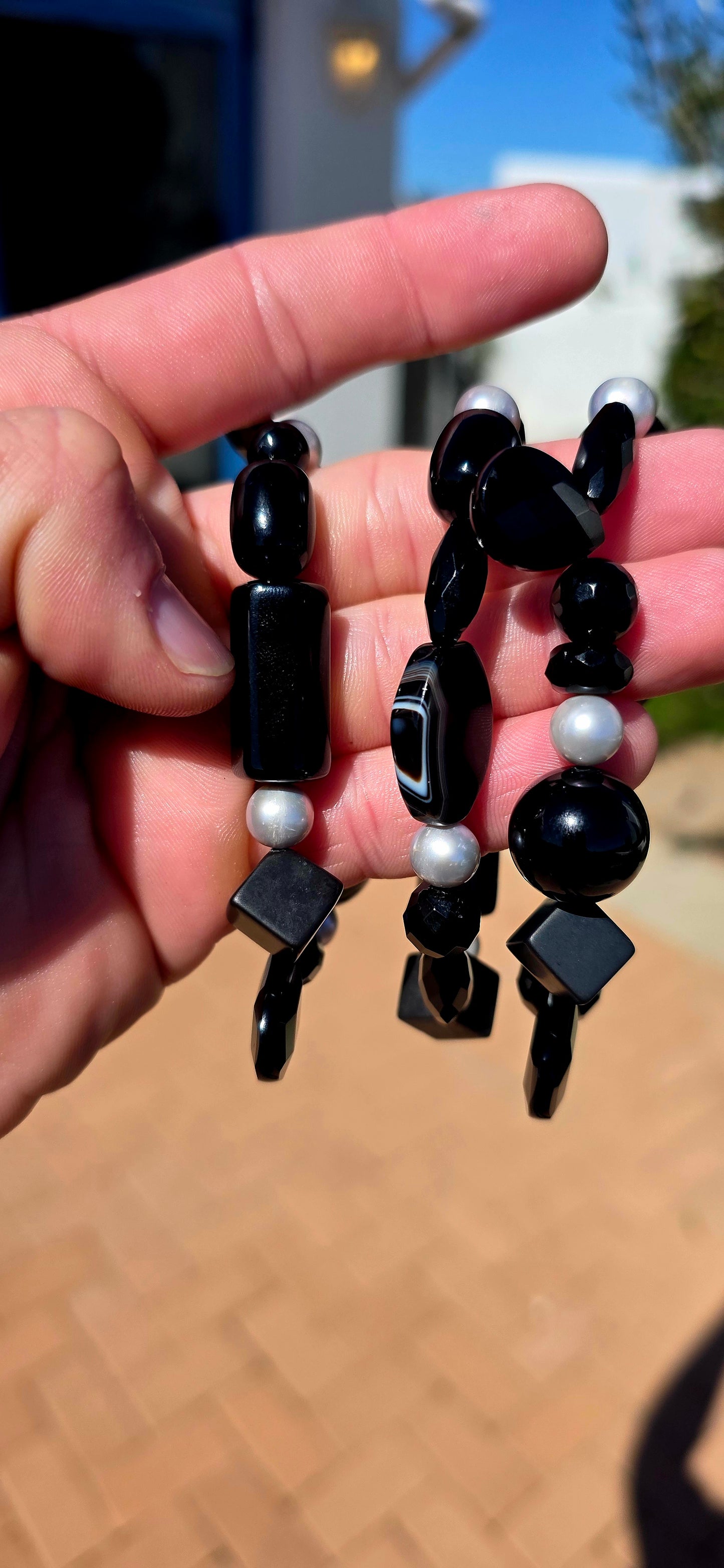A fabulous collection of chunky gemstone stretch bracelets in dramatic shades of glossy black, beautifully contrasted with luminous freshwater pearls.