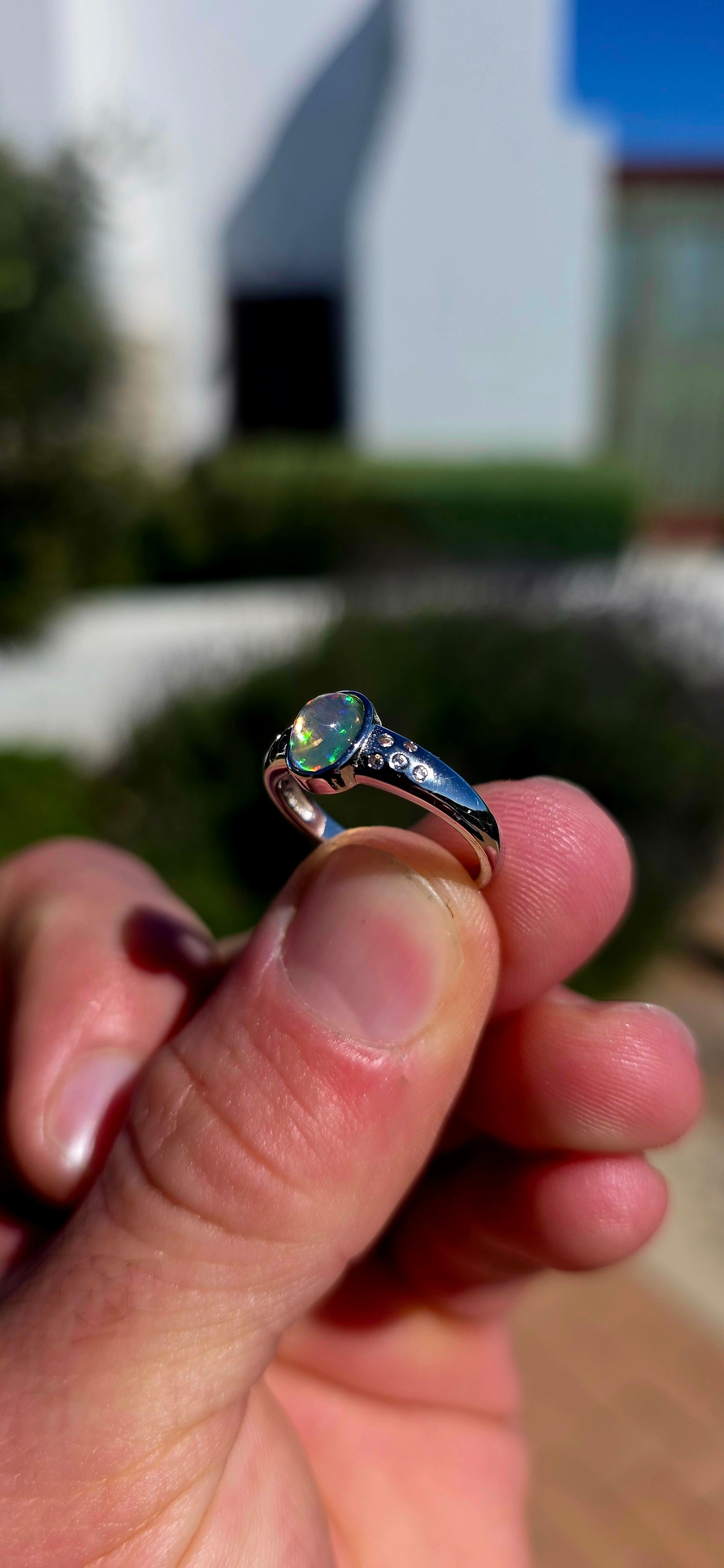 Pure little flashes of magic! This beautiful sterling silver solitaire-style ring centres around an oval Ethiopian Welo water opal cabochon, smoothly tube-set to really let that incredible natural play-of-colour take centre stage.
