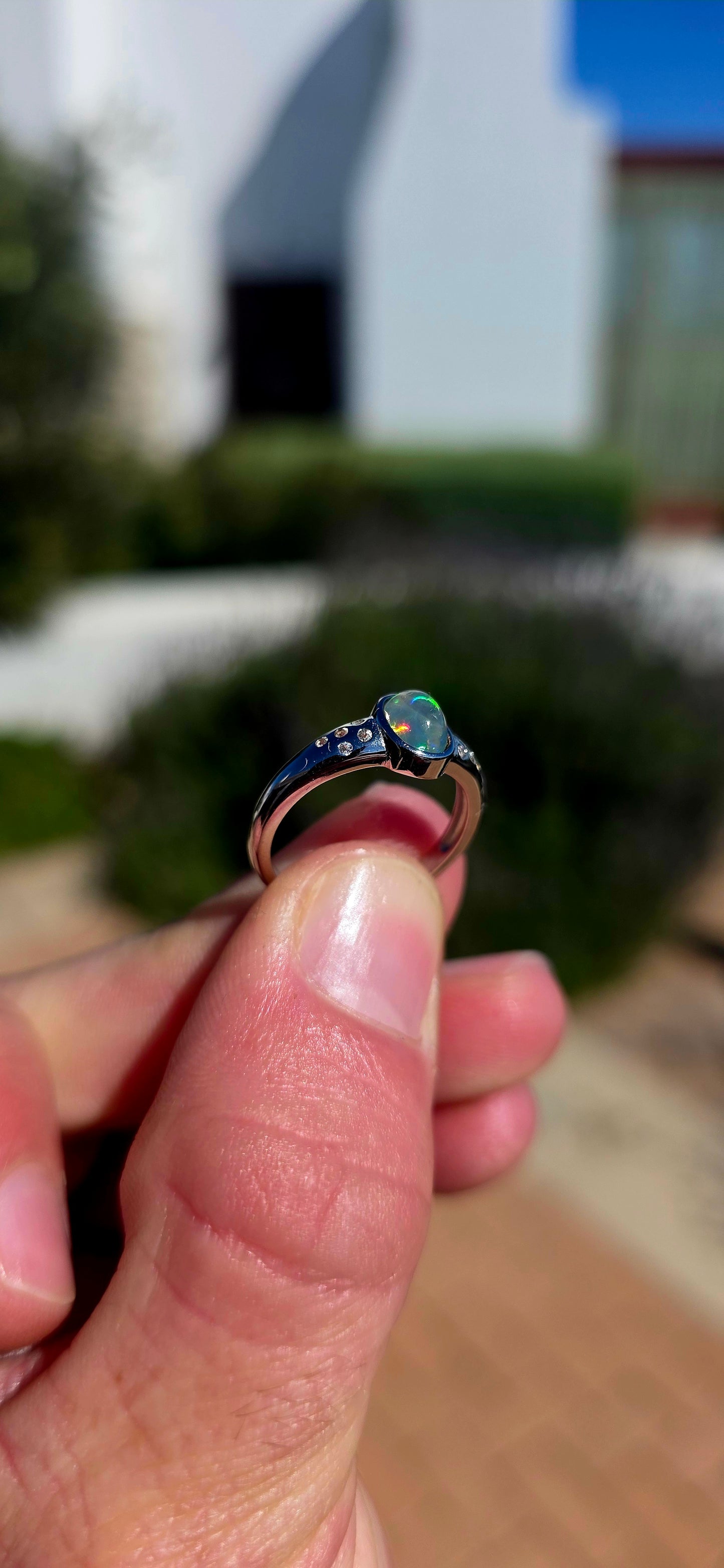 Pure little flashes of magic! This beautiful sterling silver solitaire-style ring centres around an oval Ethiopian Welo water opal cabochon, smoothly tube-set to really let that incredible natural play-of-colour take centre stage.