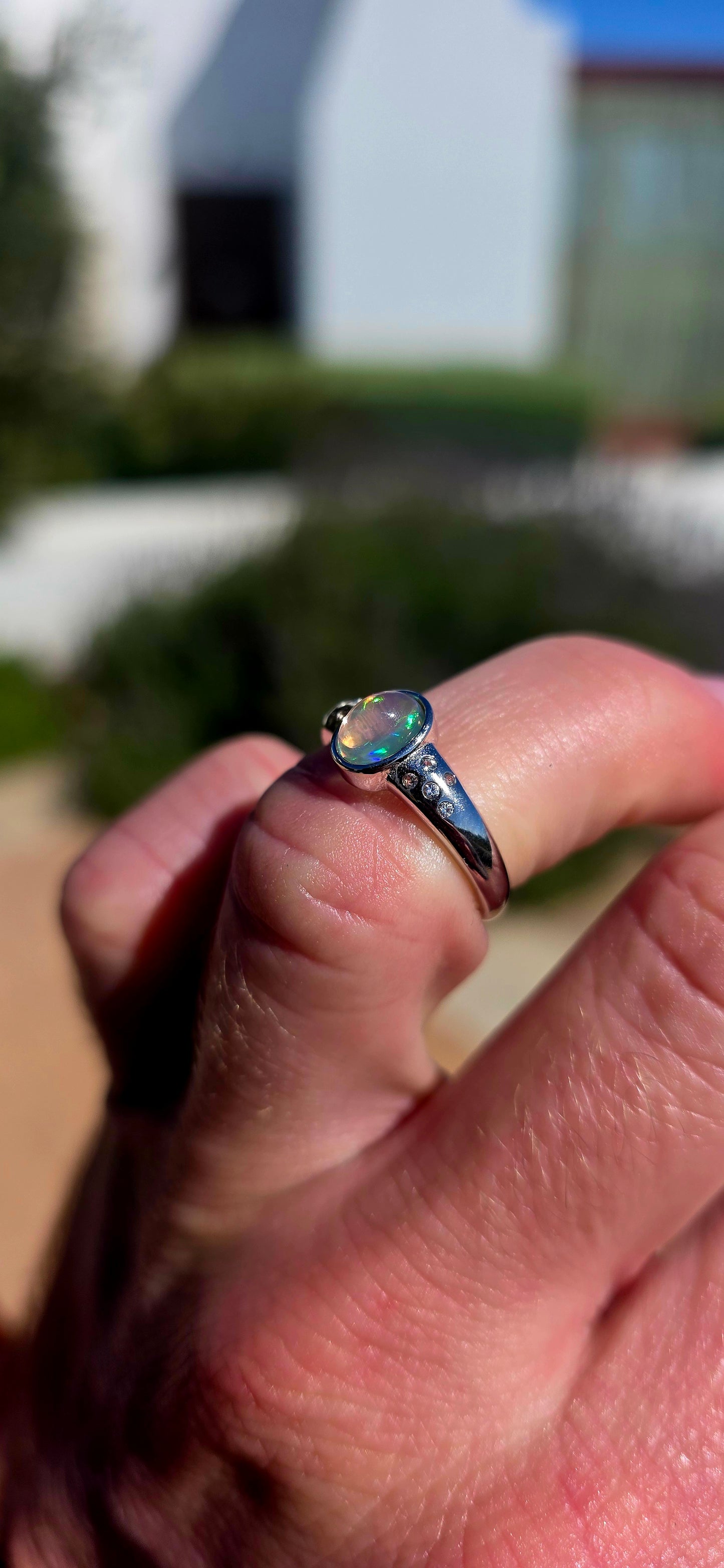 Pure little flashes of magic! This beautiful sterling silver solitaire-style ring centres around an oval Ethiopian Welo water opal cabochon, smoothly tube-set to really let that incredible natural play-of-colour take centre stage.