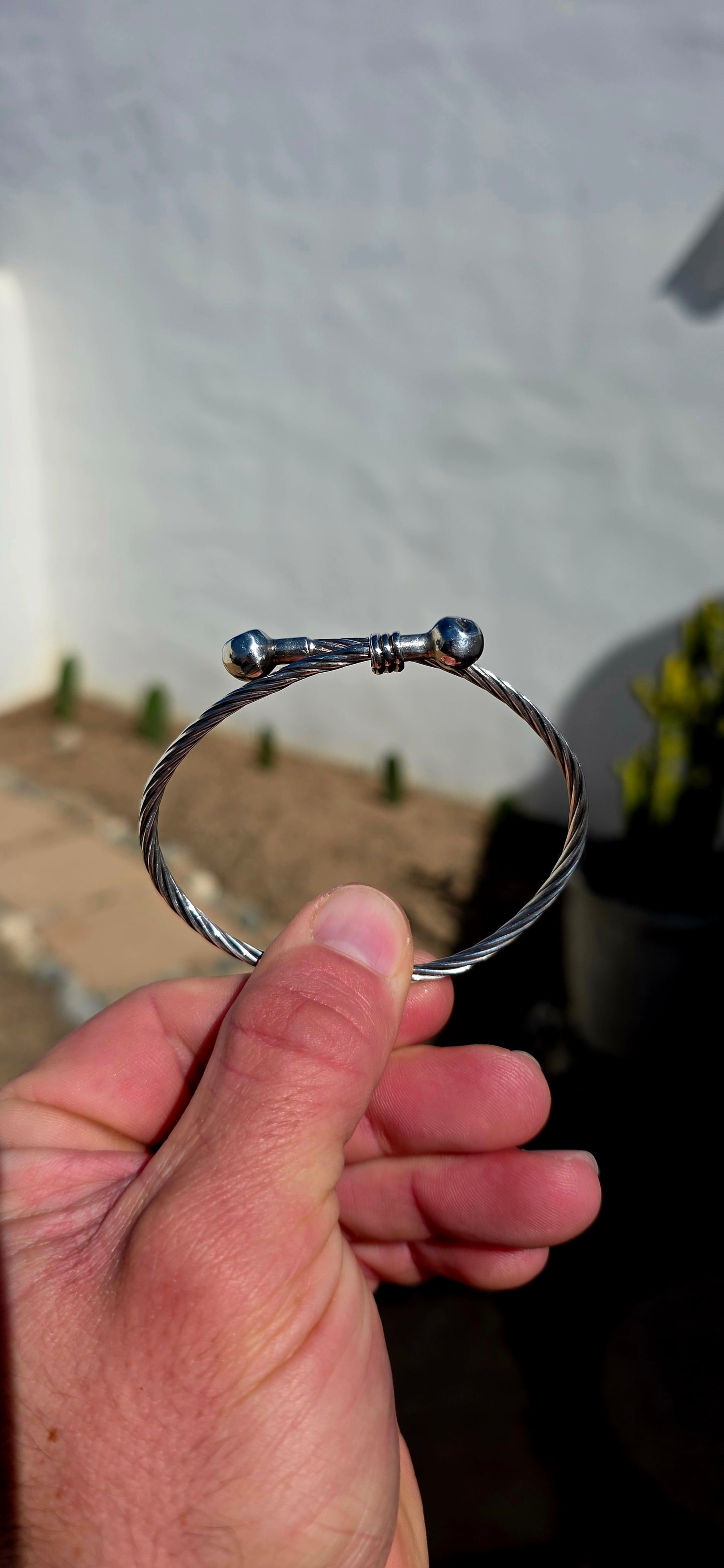 Simple, chunky and UNISEX! This vintage sterling silver bracelet features a fabulous twisted cable-style band, wrapping around the wrist and finished with two polished spherical terminals.