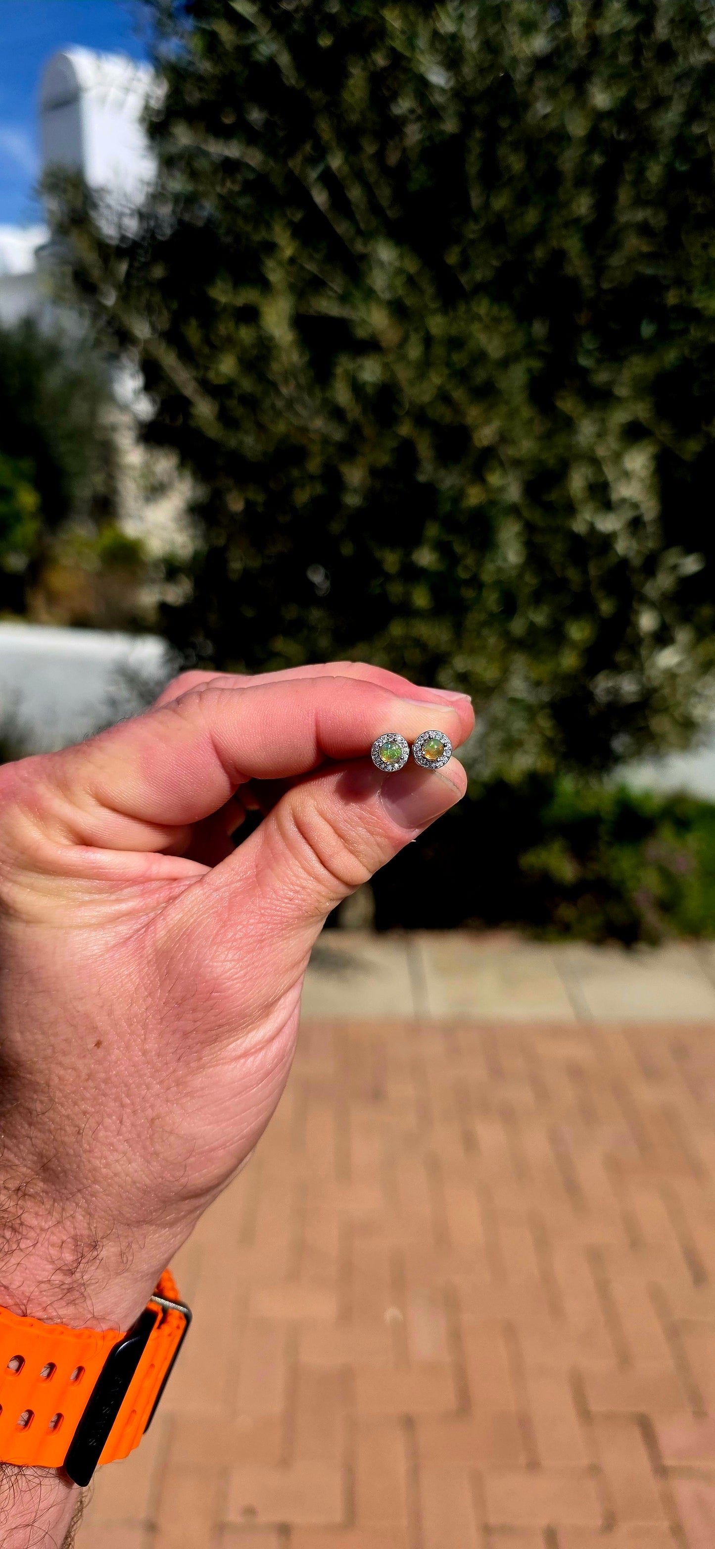 Small but absolutely magical! These beautiful stud earrings are crafted in solid sterling silver, each centred with a round natural Ethiopian opal cabochon, securely prong-set and surrounded by a delicate halo of sparkling CZ gemstones.