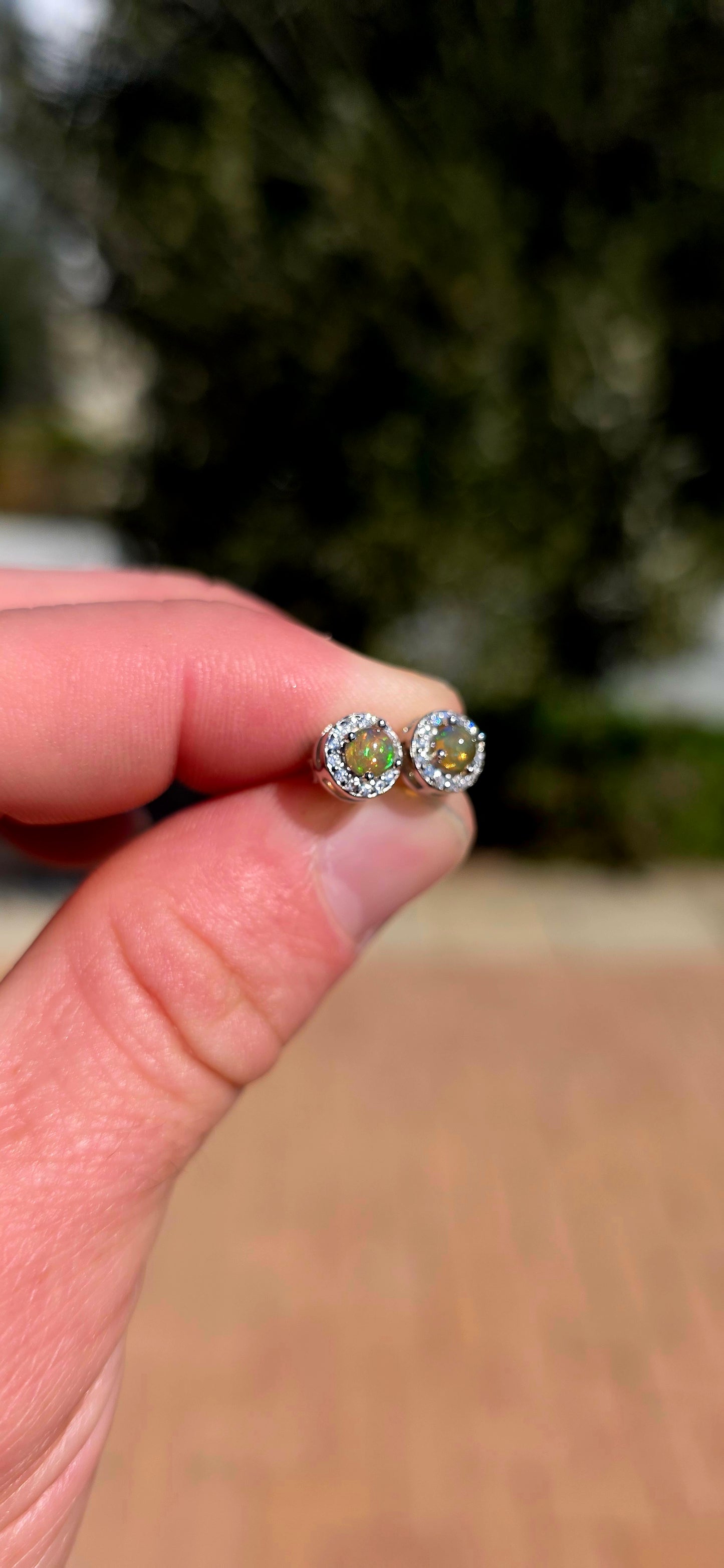 Small but absolutely magical! These beautiful stud earrings are crafted in solid sterling silver, each centred with a round natural Ethiopian opal cabochon, securely prong-set and surrounded by a delicate halo of sparkling CZ gemstones.