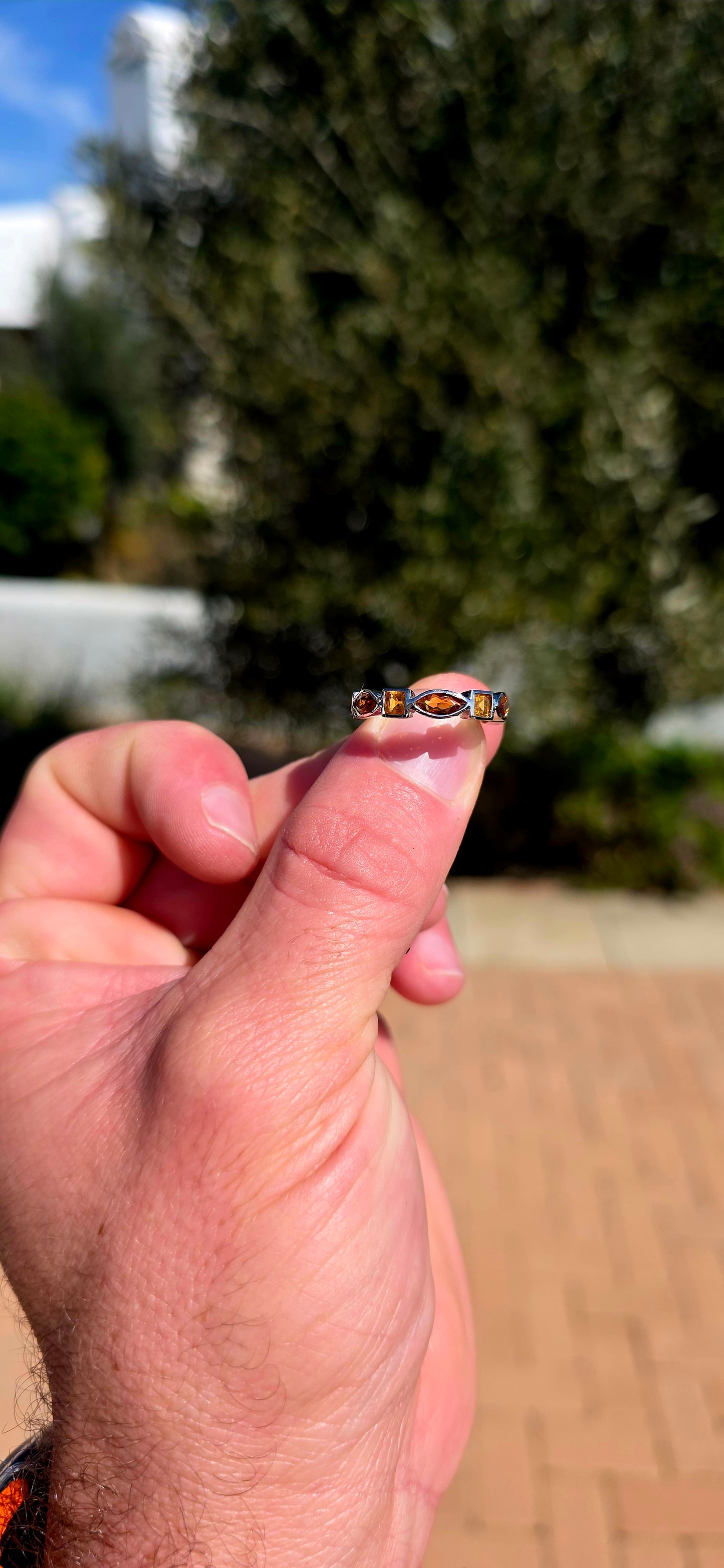 What a fabulous burst of sunshine! This beautiful sterling silver half-eternity ring is tube-set with alternating citrine gemstones, combining princess and marquise cuts in gorgeous shades of golden yellow, honey and deep burnt orange.