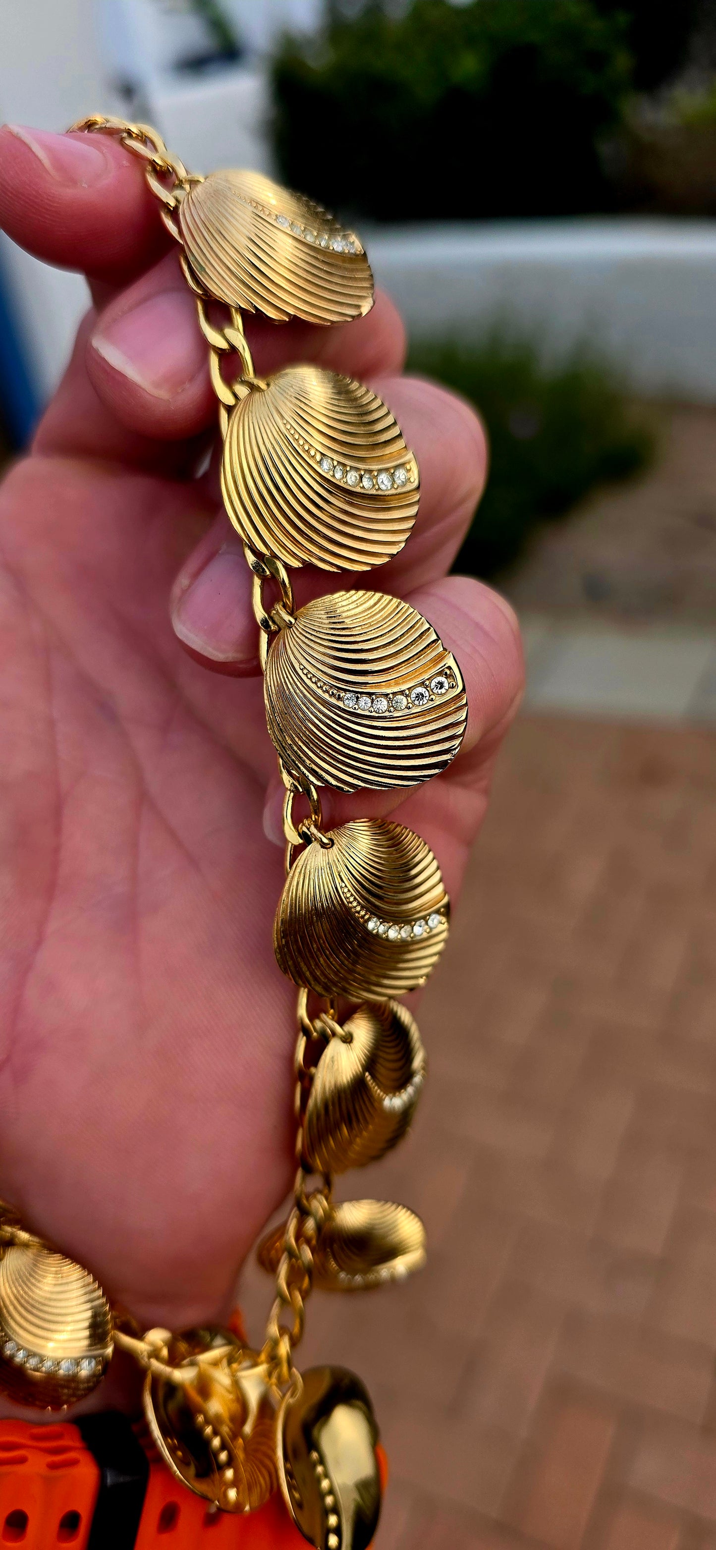 Dating to the 1980s, this striking vintage necklace by D-i-o-r is beautifully crafted in rich gold-plated metal and features an elongated curb-link chain dripping with 15 wonderfully dimensional shell charms.
