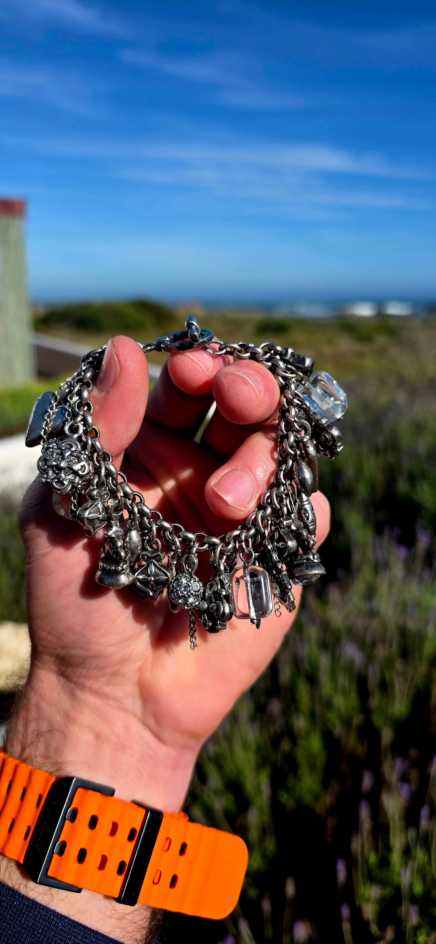 More is MORE! A fabulous chunky designer costume charm bracelet by Miglio, crafted in silver-plated metal and absolutely loaded with an eclectic collection of antique-inspired charms.