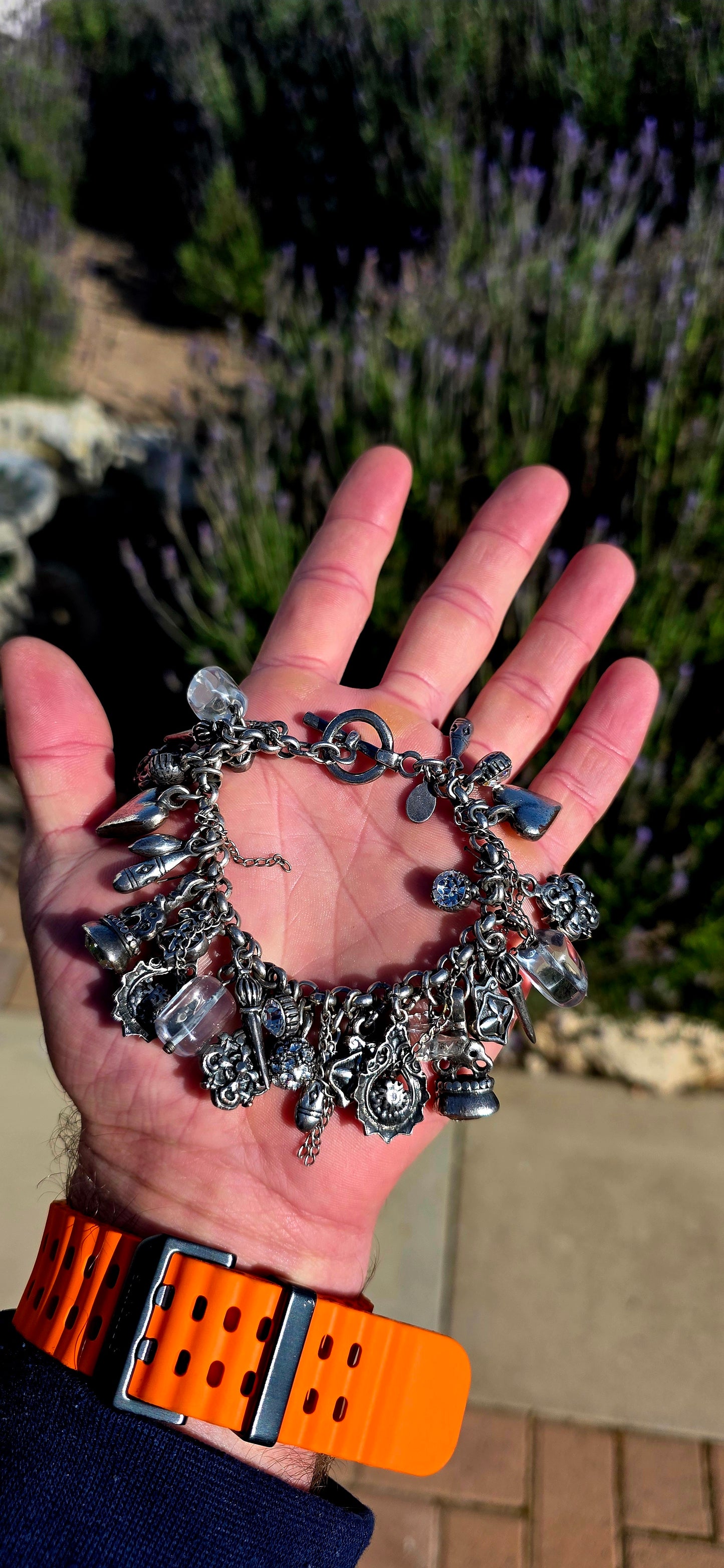 More is MORE! A fabulous chunky designer costume charm bracelet by Miglio, crafted in silver-plated metal and absolutely loaded with an eclectic collection of antique-inspired charms.