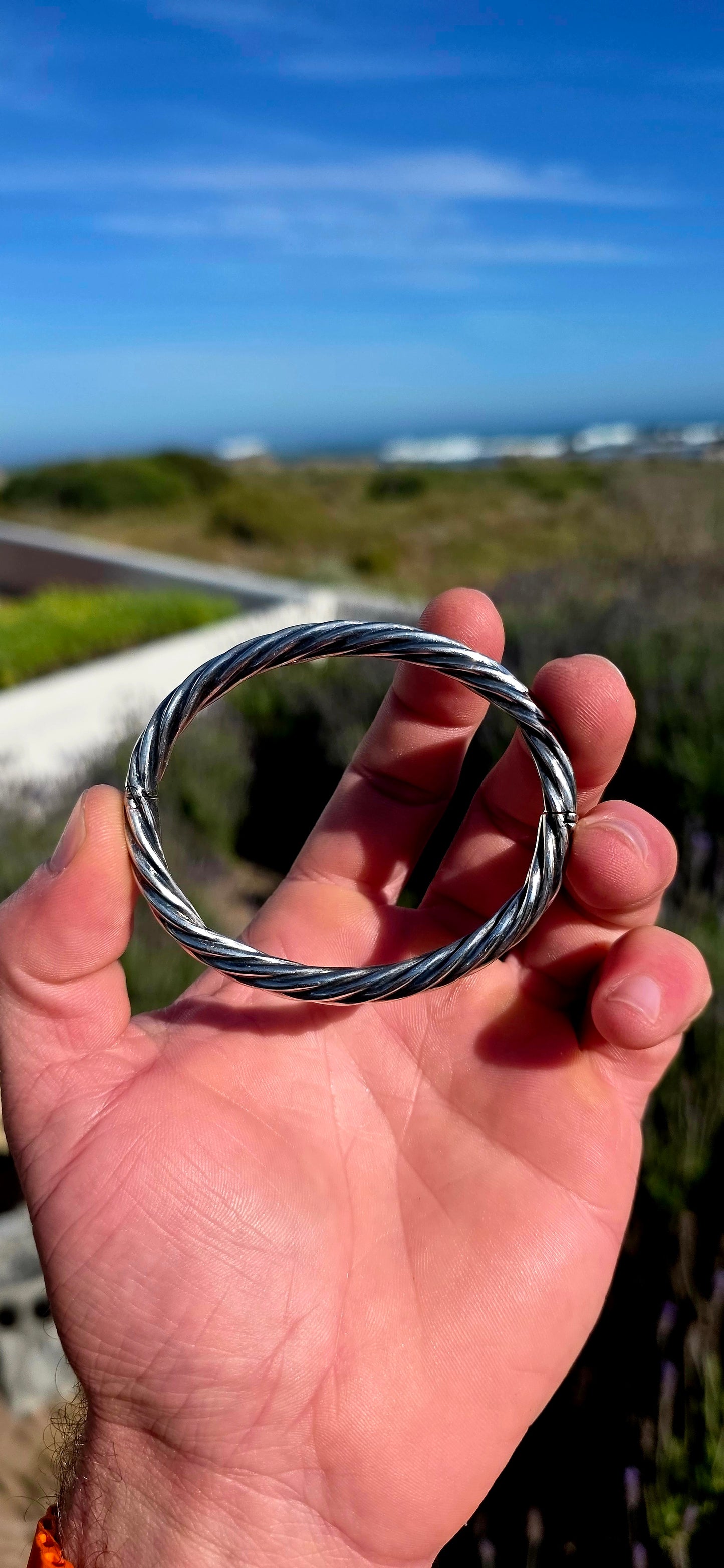 Fabulous and beautifully UNISEX! This vintage Italian bangle is crafted in sterling silver with a classic oval profile and a wonderful twisted tubular design.