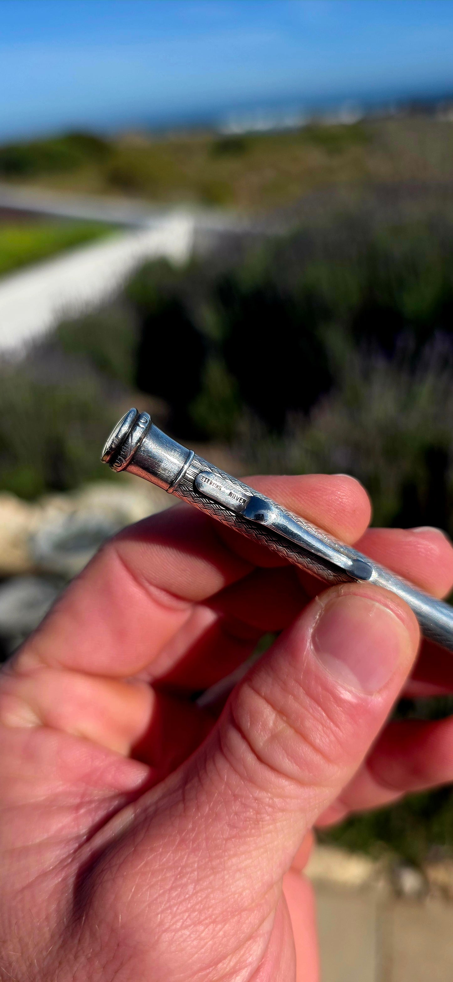 Dating to circa 1920s, this antique mechanical propelling pencil is crafted in solid sterling silver, with the slender body beautifully decorated in a fine engine-turned geometric pattern.