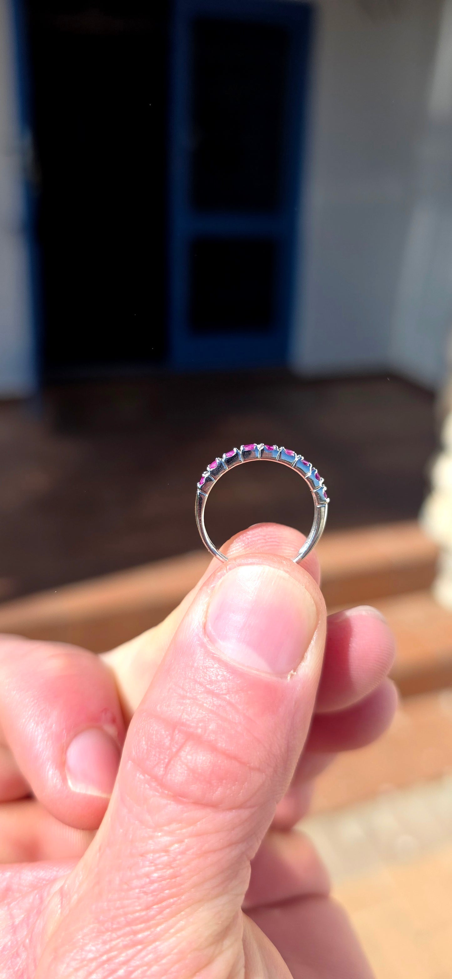 Delicate, feminine and made for stacking! This petite sterling silver half-eternity ring features a neat row of nine round-cut natural rubies, individually set across the front of the slender band.