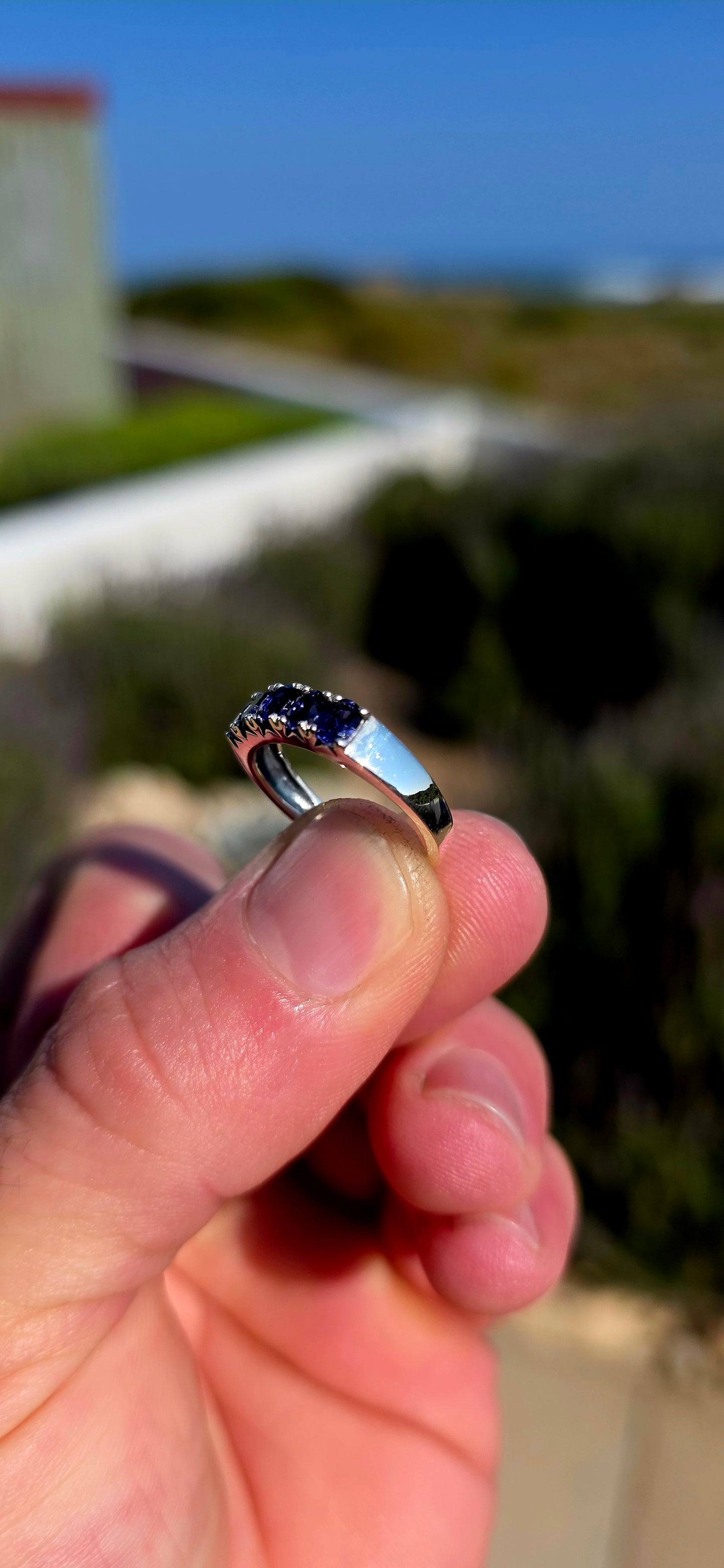 Understated, elegant and wonderfully easy to wear! This sterling silver half-eternity stacking ring is beautifully prong-set across the front with five oval-cut natural iolite gemstones.