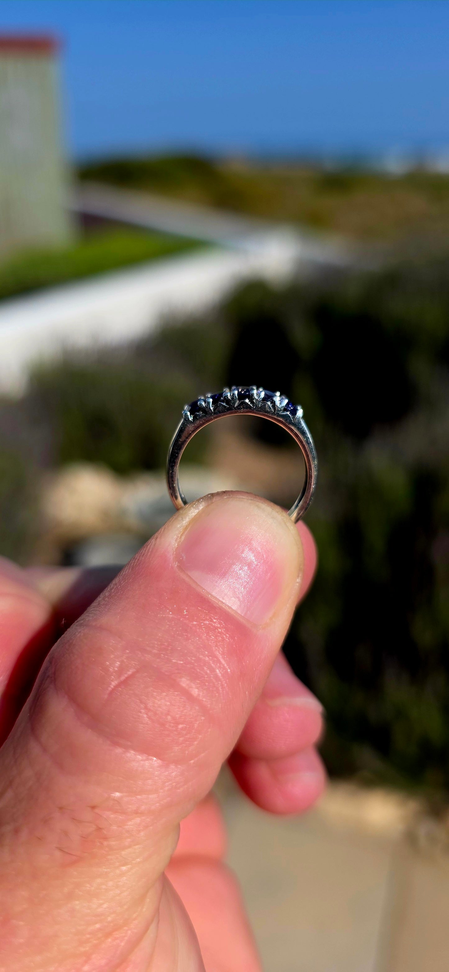 Understated, elegant and wonderfully easy to wear! This sterling silver half-eternity stacking ring is beautifully prong-set across the front with five oval-cut natural iolite gemstones.