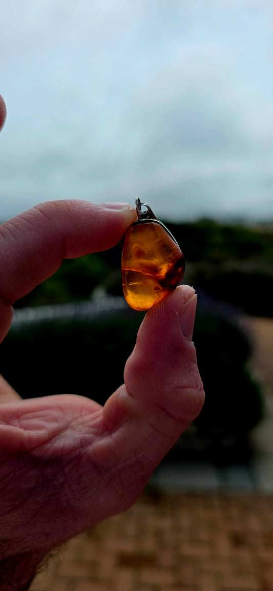 Ancient looking and absolutely gorgeous! This antique sterling silver pendant celebrates amber in its most beautifully organic form — irregular, earthy and completely individual.