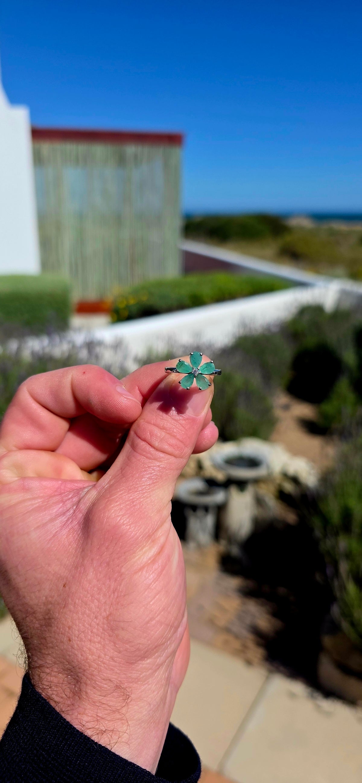 Feminine, magical and bursting with colour — this gorgeous sterling silver ring is like a little emerald flower blooming across the finger!