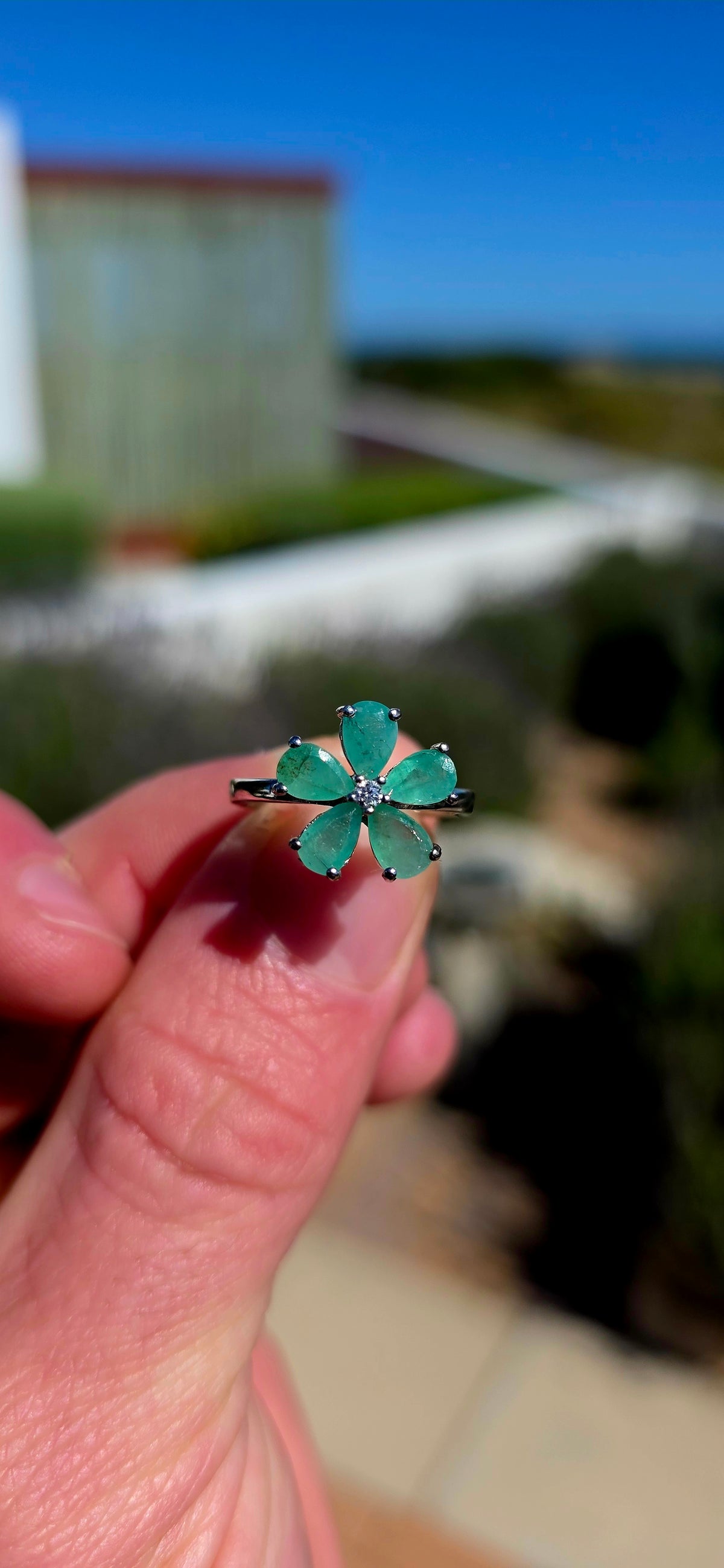 Feminine, magical and bursting with colour — this gorgeous sterling silver ring is like a little emerald flower blooming across the finger!