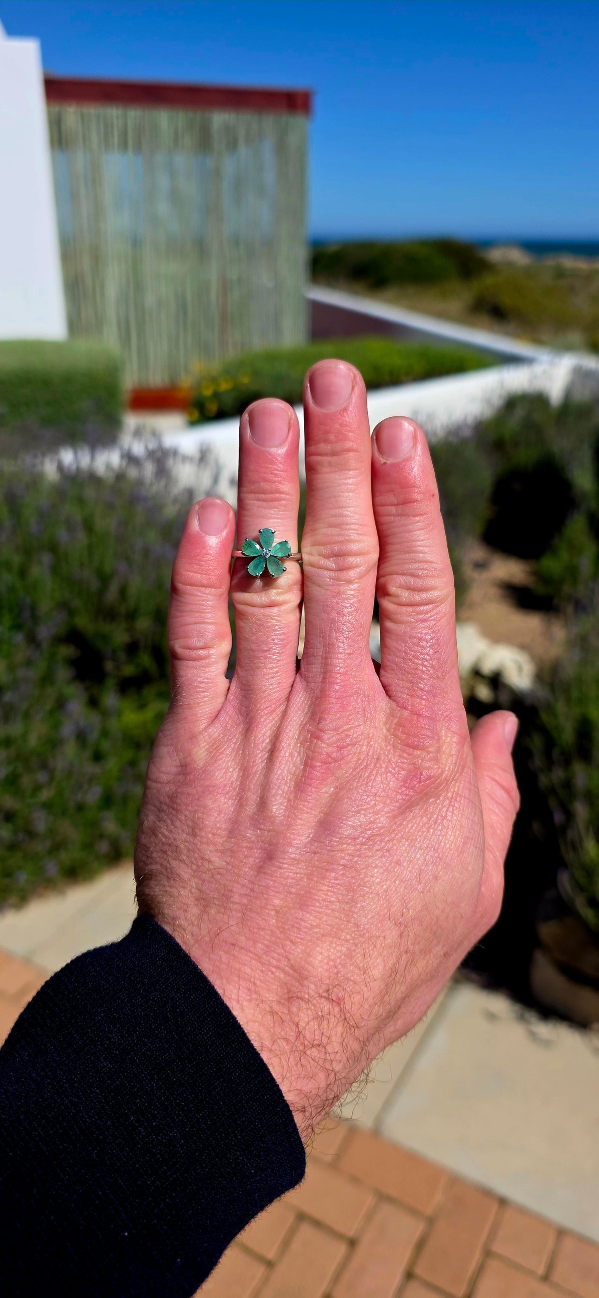 Feminine, magical and bursting with colour — this gorgeous sterling silver ring is like a little emerald flower blooming across the finger!