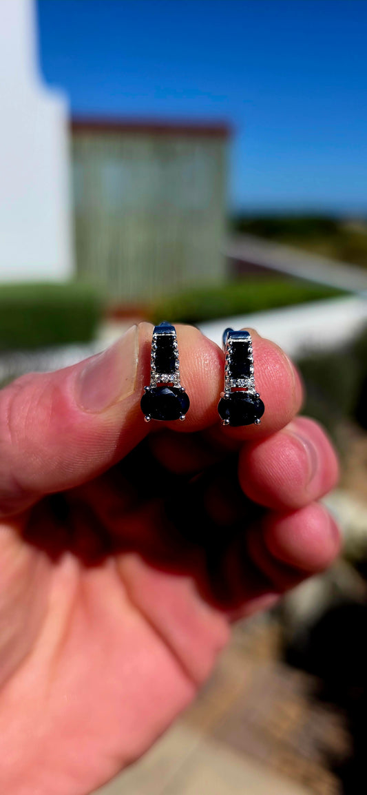 These elegant sterling silver earrings carry through a gorgeous combination of deep blue sapphires and crisp white sparkle.