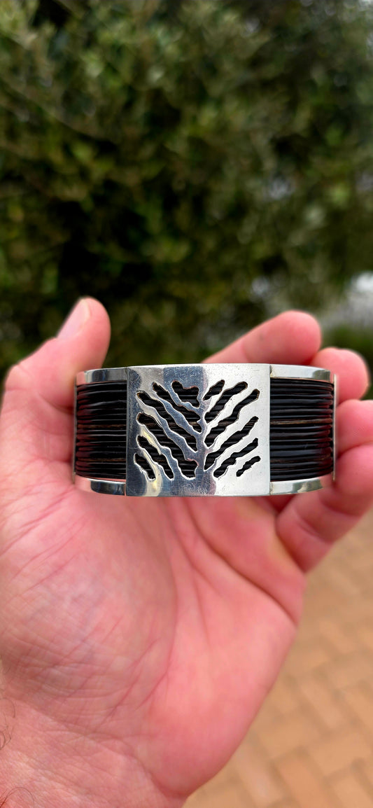 Bold, wonderfully tactile and perfectly UNISEX — this chunky open cuff bracelet combines polished sterling silver with multiple strands of genuine elephant hair, creating a striking contrast between the cool silver and rich dark natural fibres.