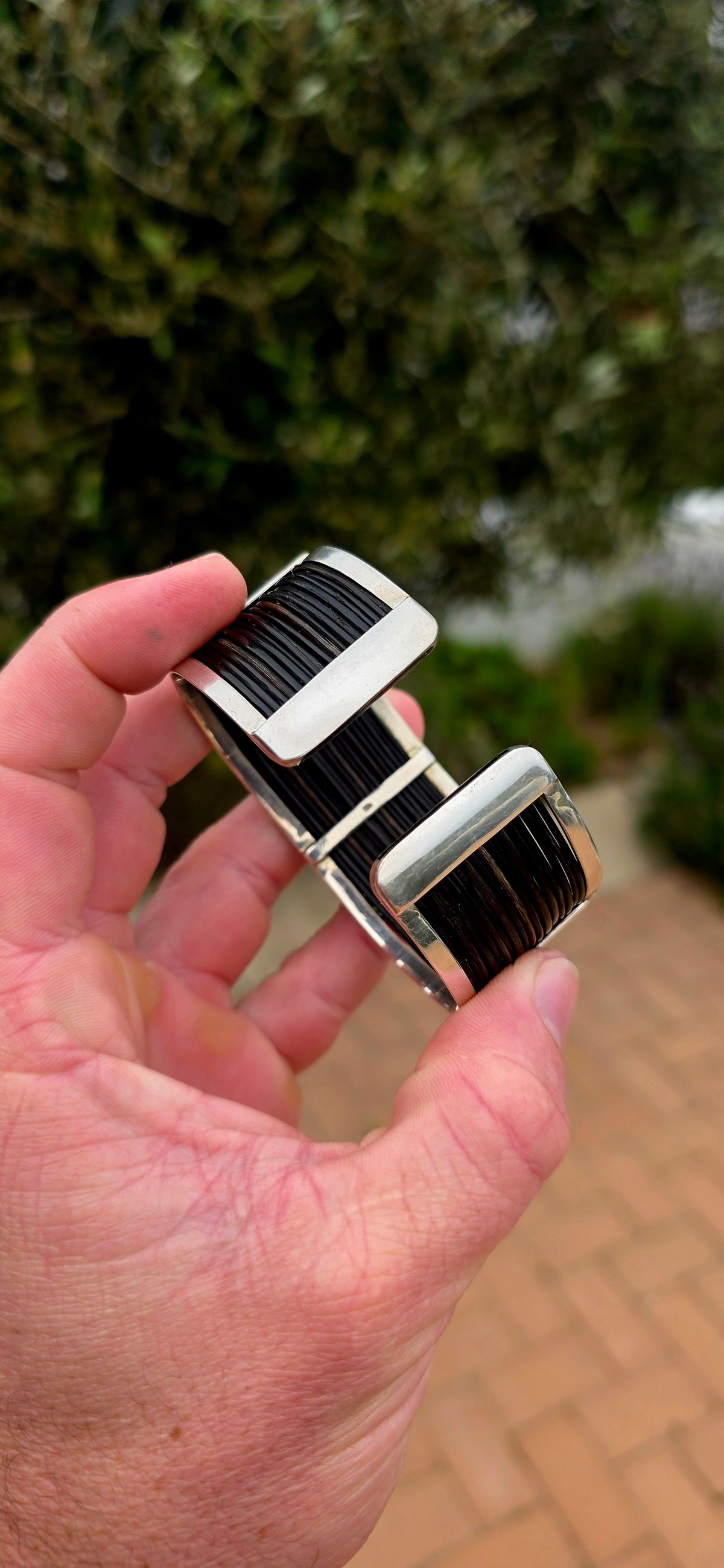 Bold, wonderfully tactile and perfectly UNISEX — this chunky open cuff bracelet combines polished sterling silver with multiple strands of genuine elephant hair, creating a striking contrast between the cool silver and rich dark natural fibres.