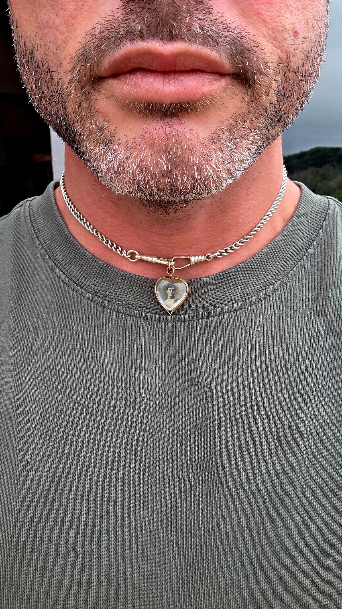 This antique Edwardian-era heart-shaped fob pendant features miniature photographic portraits of King Edward VII and Queen Alexandra, one displayed on either side beneath protective glass.