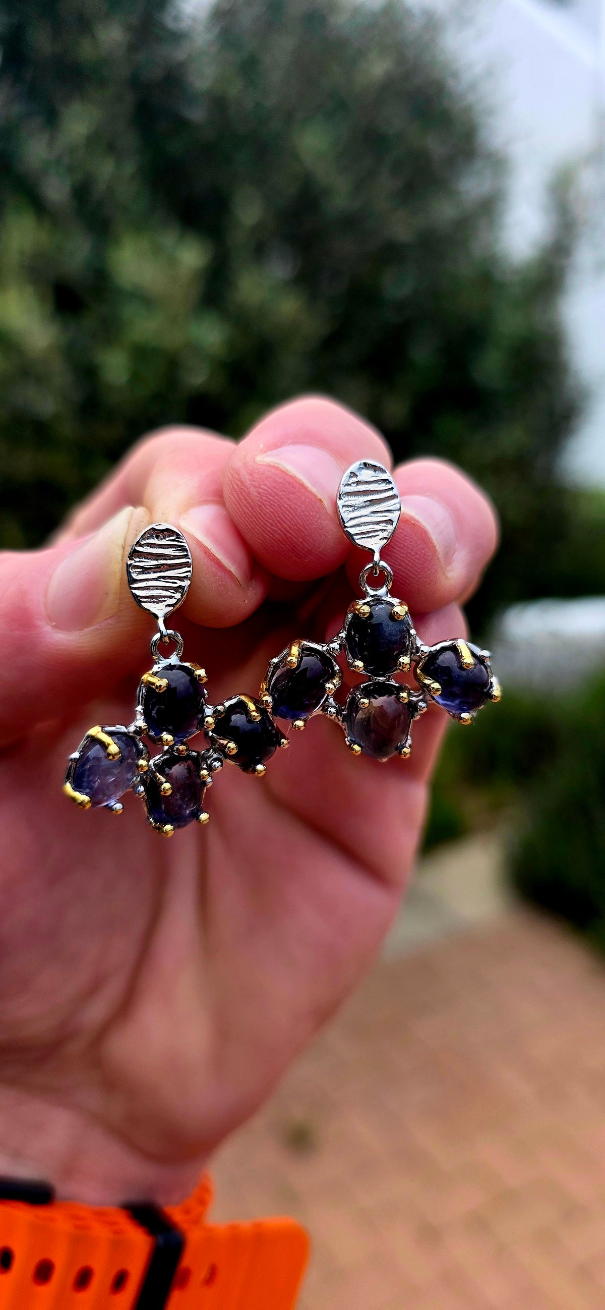 Handcrafted in sterling silver, these artisan drop earrings feature clusters of generously sized oval iolite cabochons, creating a beautifully organic floral formation beneath textured oval stud tops.